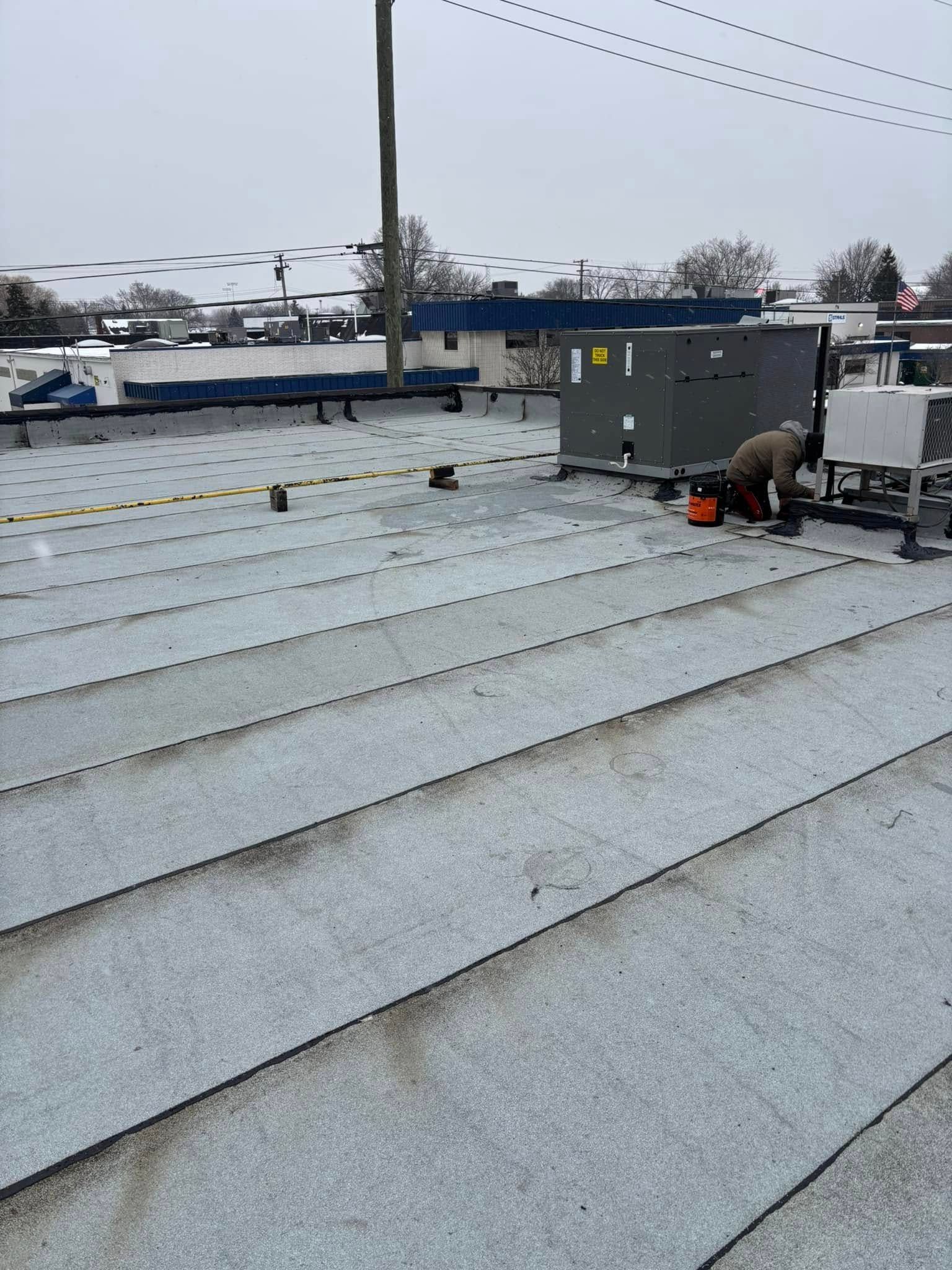 A man is working on the roof of a building.