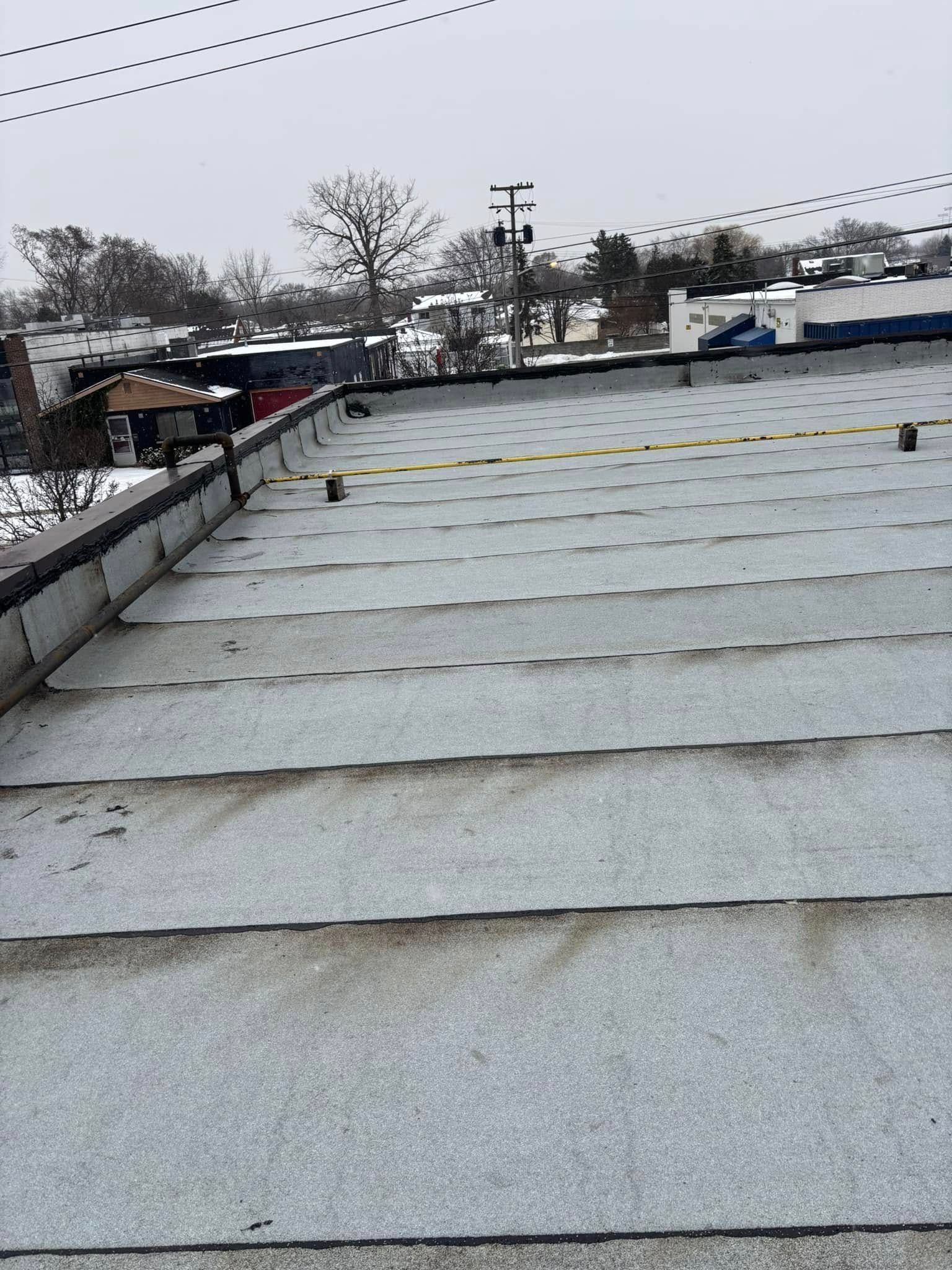 A roof with a lot of holes in it is covered in snow.