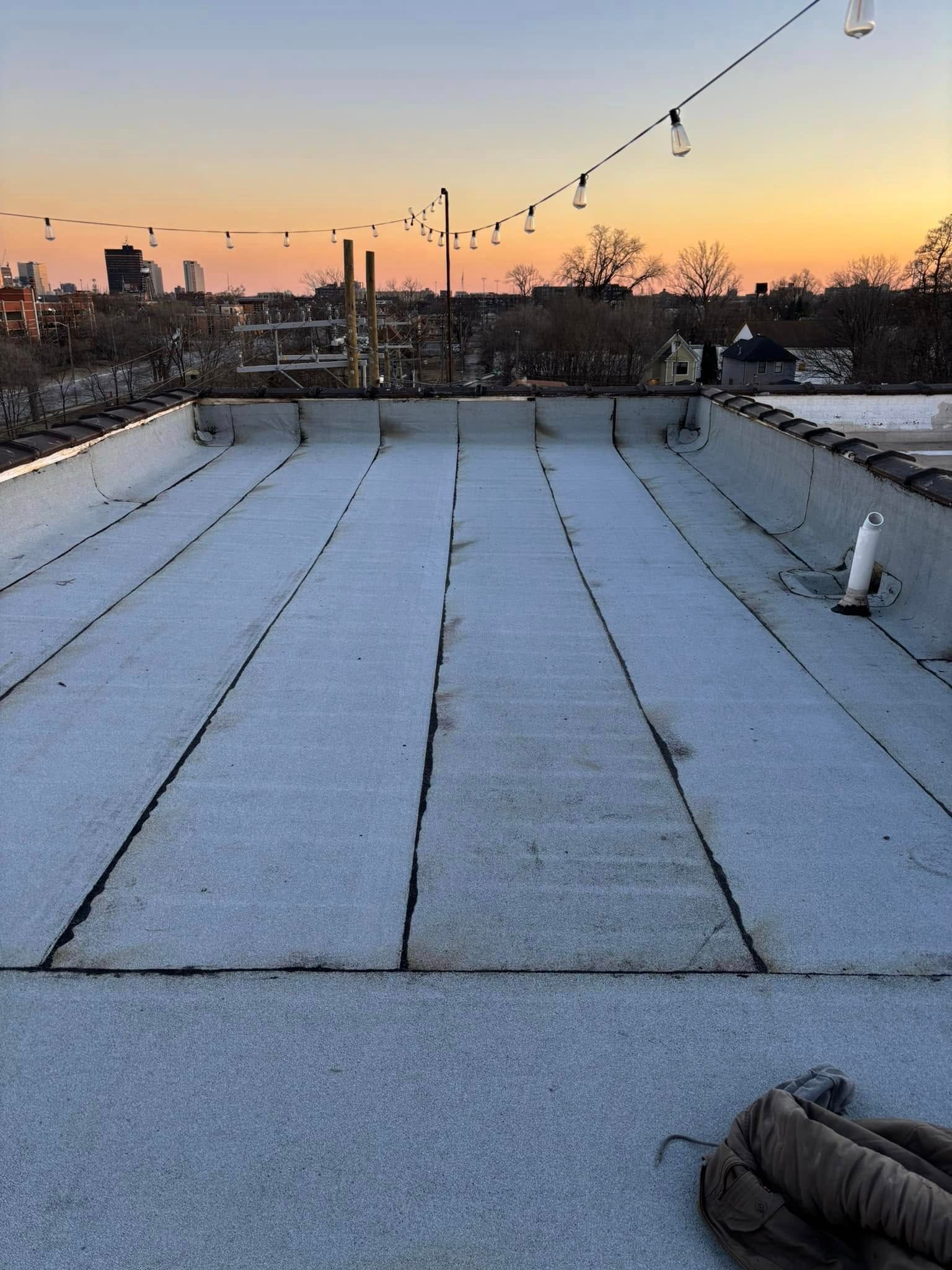A roof with a lot of lines on it and a sunset in the background.