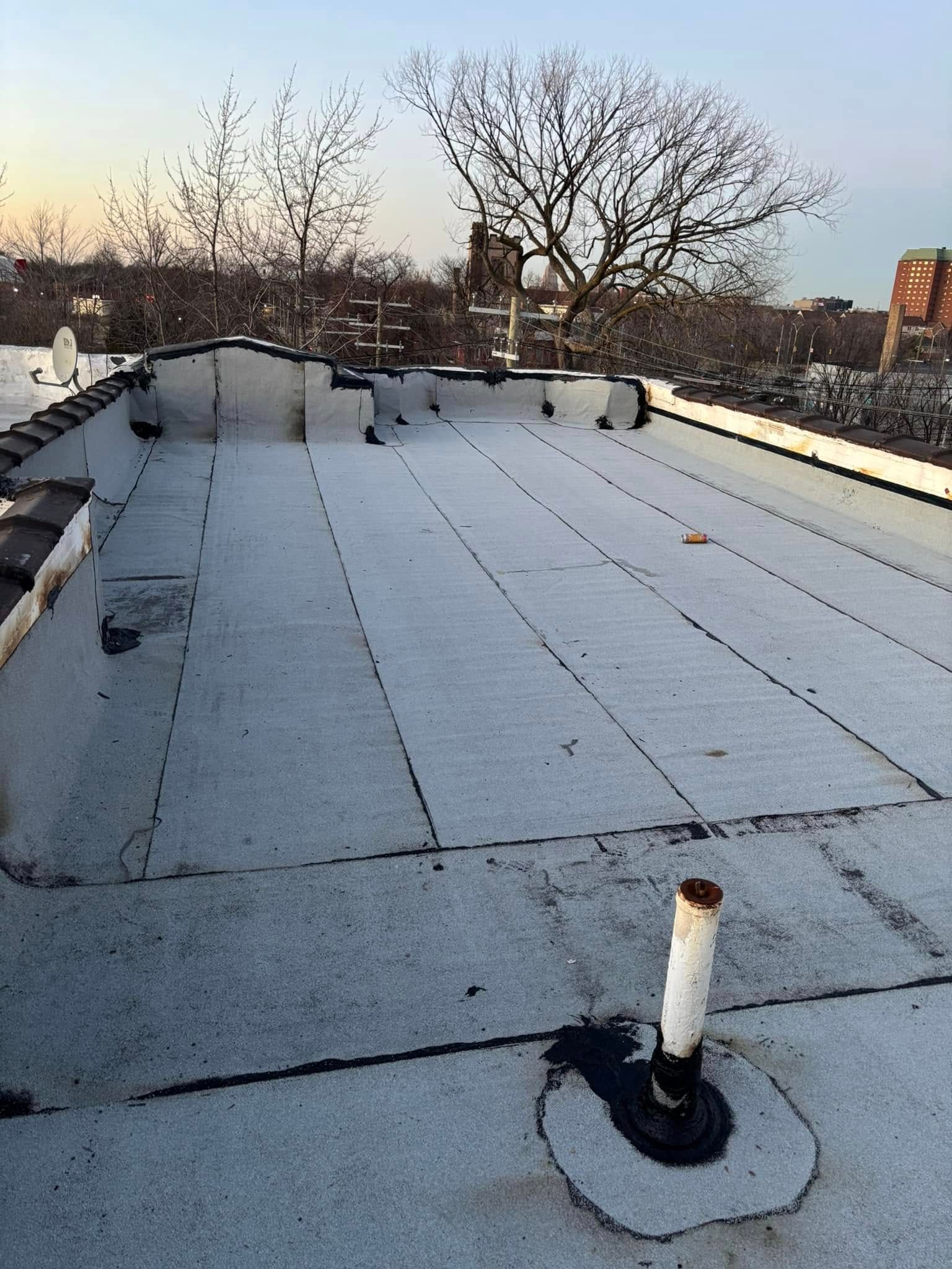 A roof with a white roof and a white pipe on it.