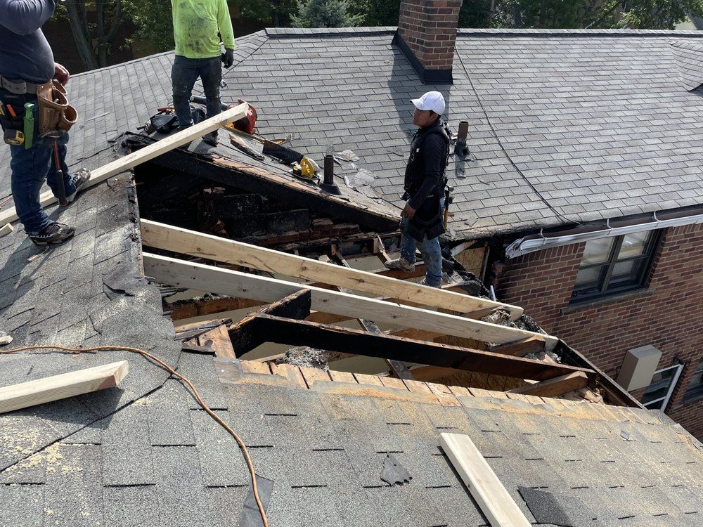 A group of men are working on the roof of a house.