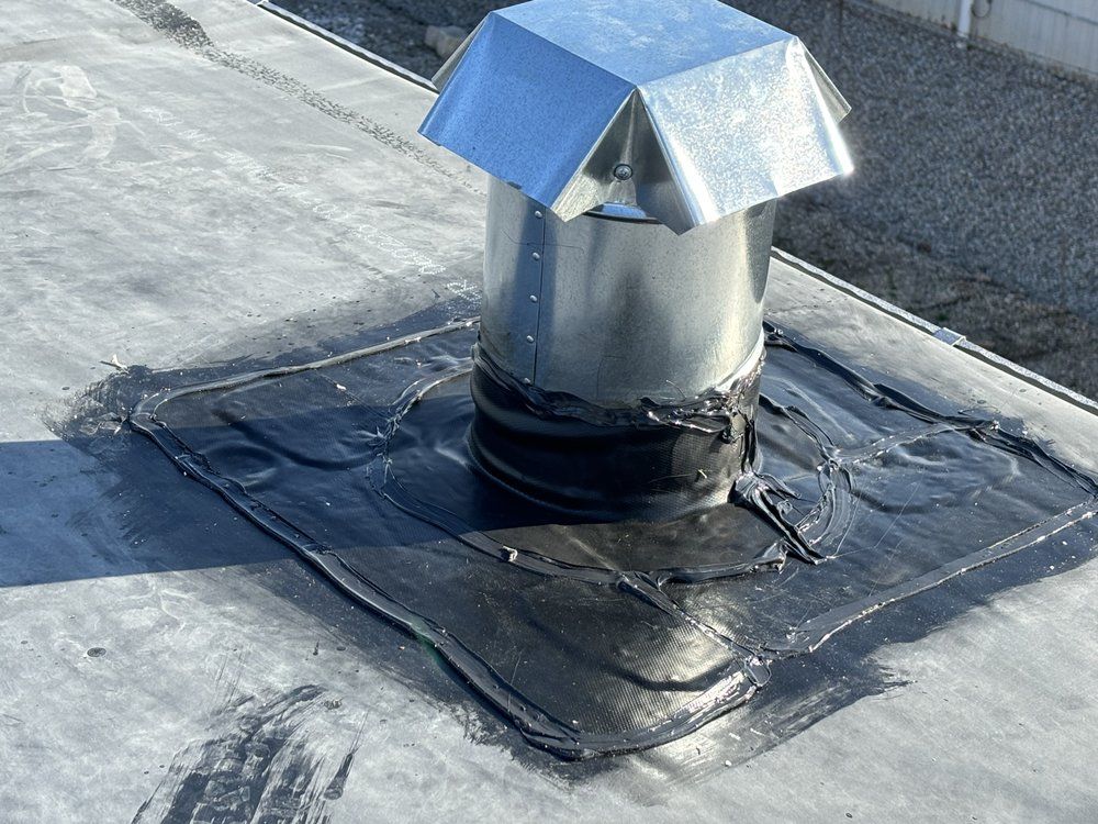 A metal pipe is sitting on top of a roof.