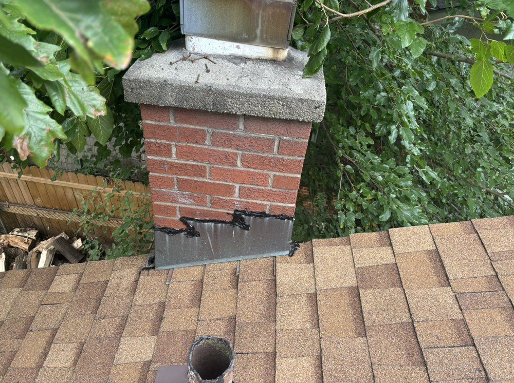 A brick chimney is sitting on top of a brick roof.