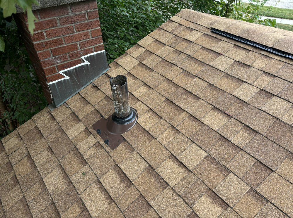 A roof with shingles and a chimney on it.