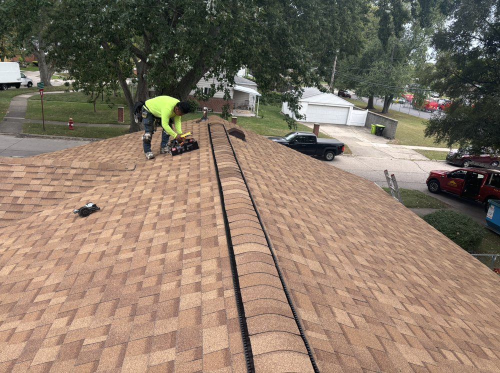 A man is working on the roof of a house.