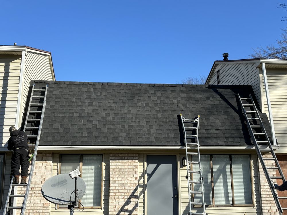 Two men are working on the roof of a house.