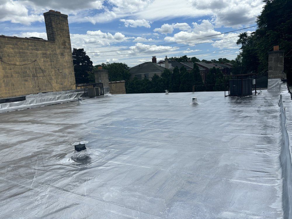 A roof with a chimney on it and trees in the background.