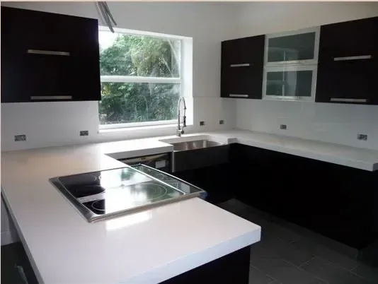 A kitchen with black cabinets and white counter tops