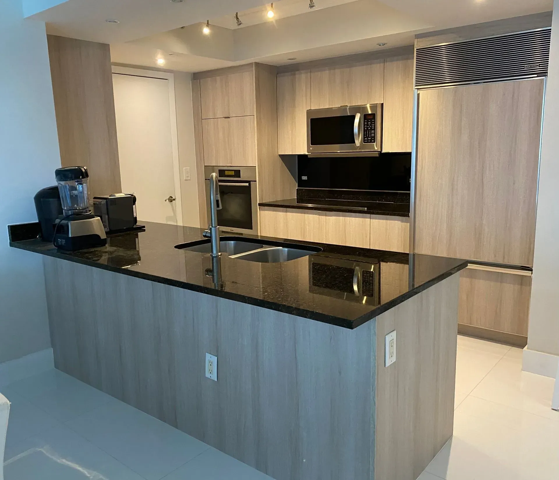 A kitchen with a large island and stainless steel appliances