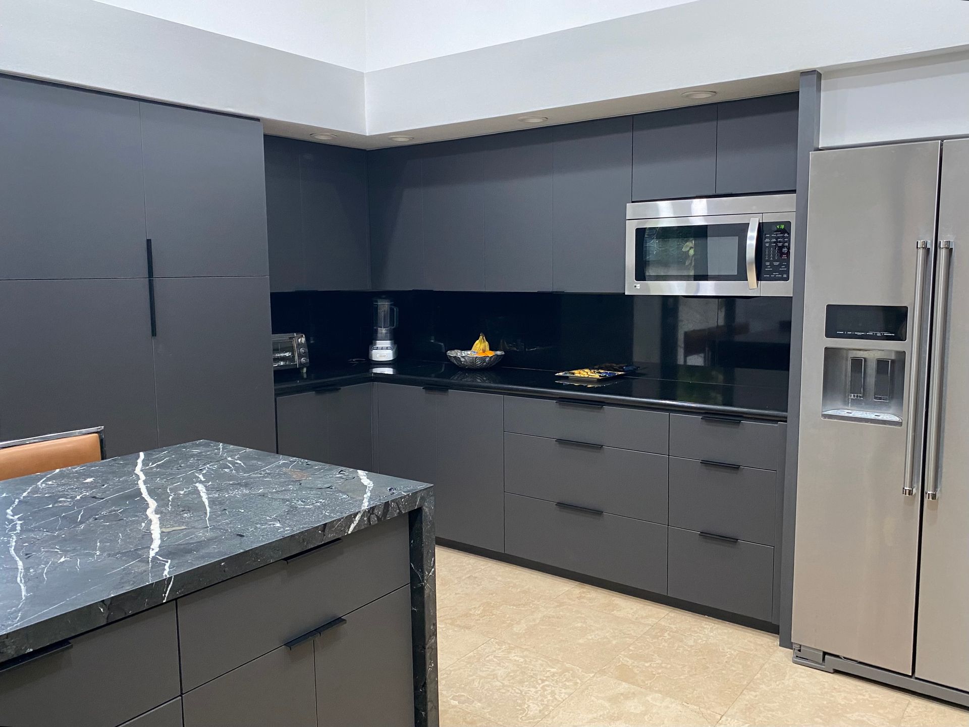 Grey kitchen cabinets with black granite countertop.