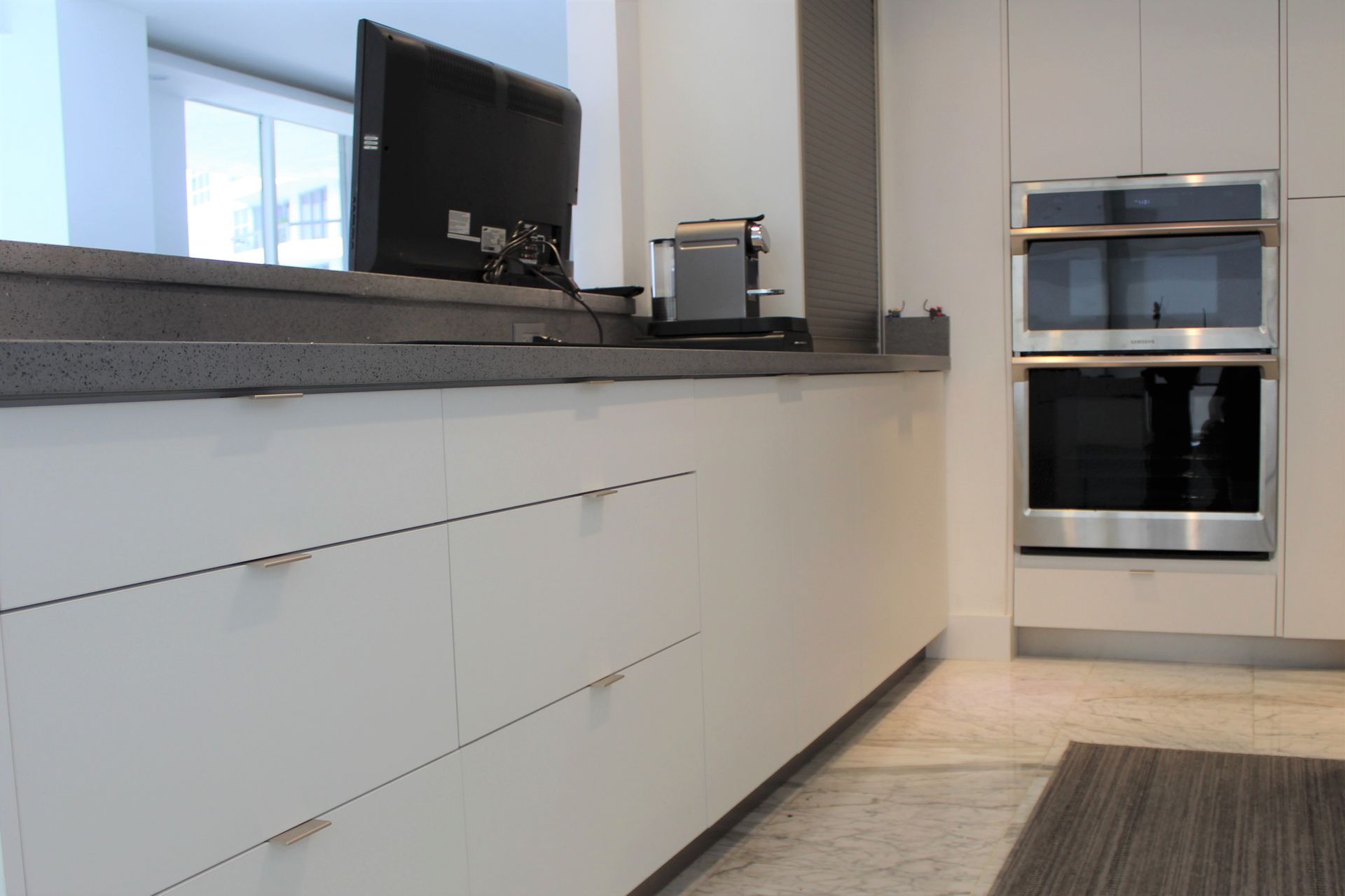 White kitchen cabinets with stainless steel appliances.
