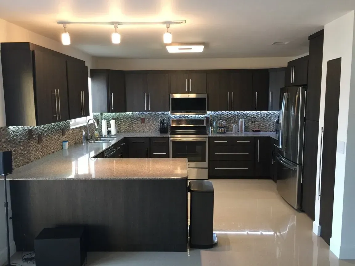 A kitchen with black cabinets and stainless steel appliances