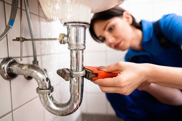 A man is fixing a faucet in a kitchen sink.