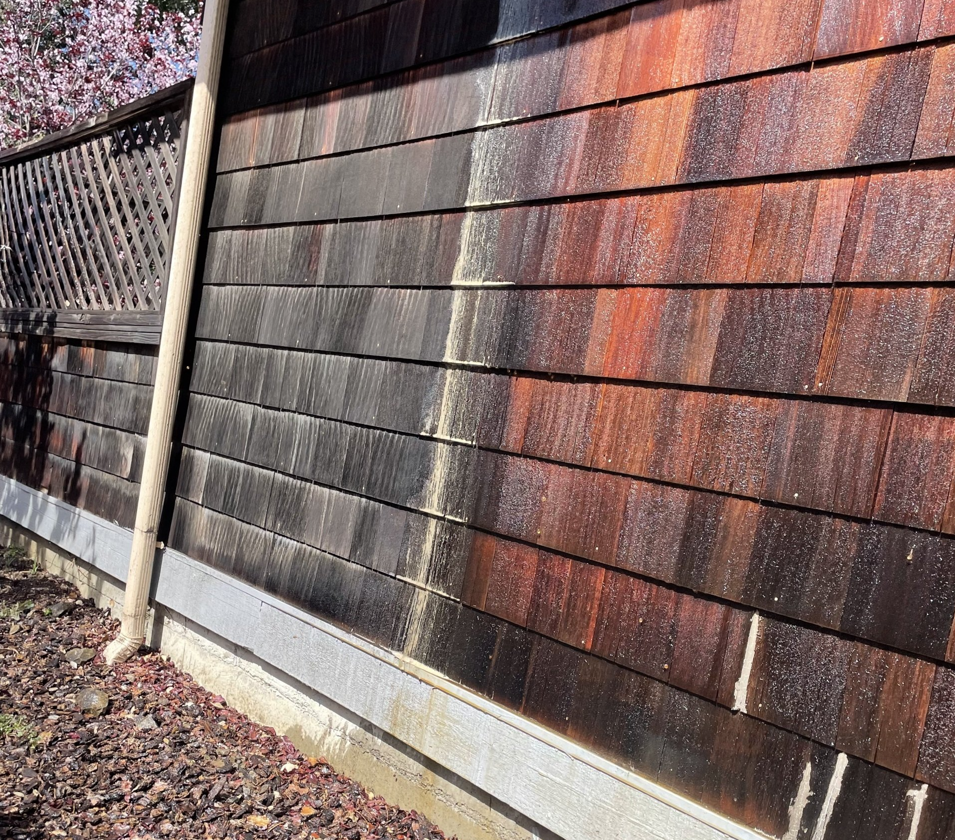 A close up of a wooden wall with a fence in the background.