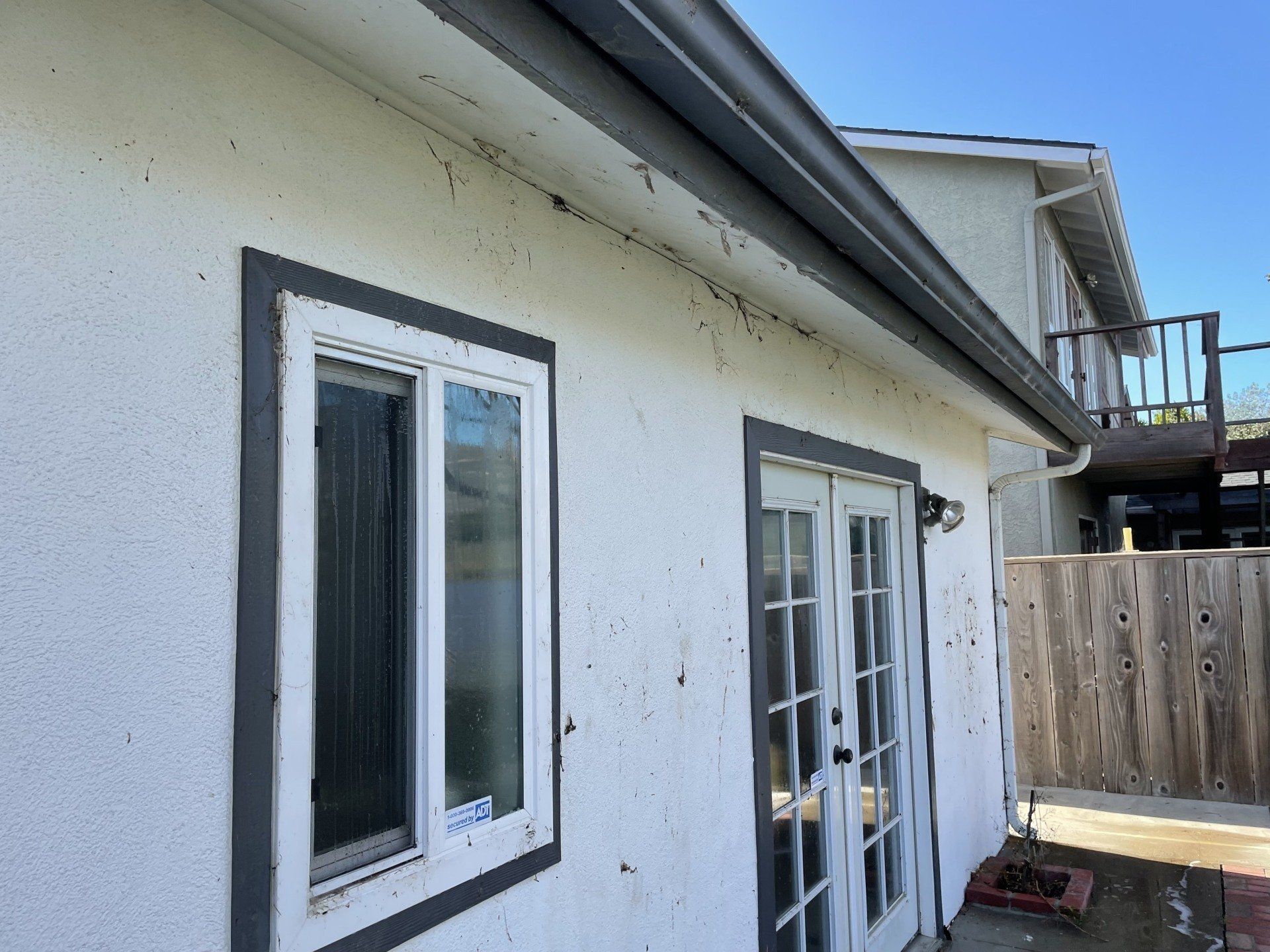 A white house with a window and sliding glass doors.