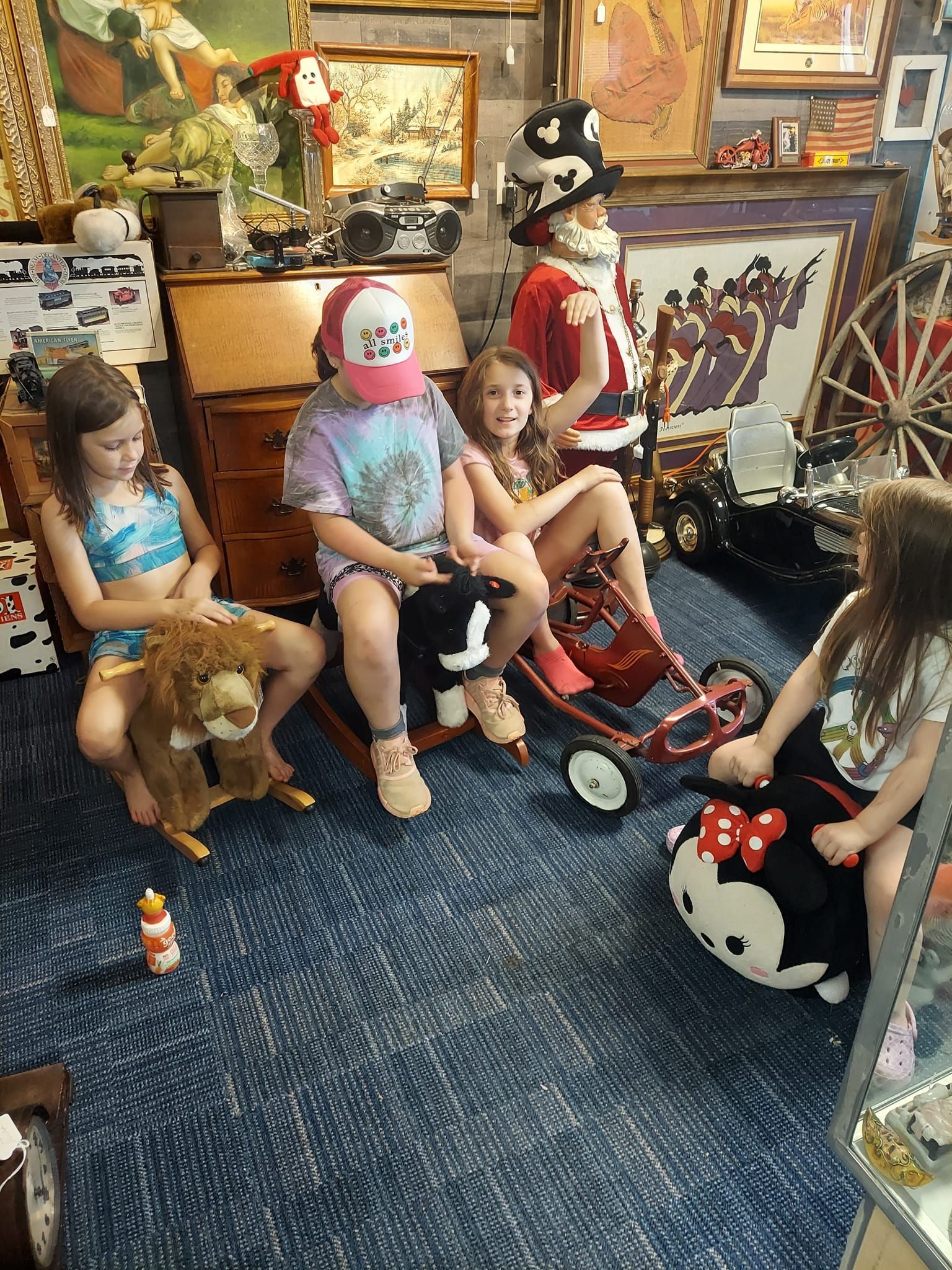 A group of children are sitting in a room with toys.
