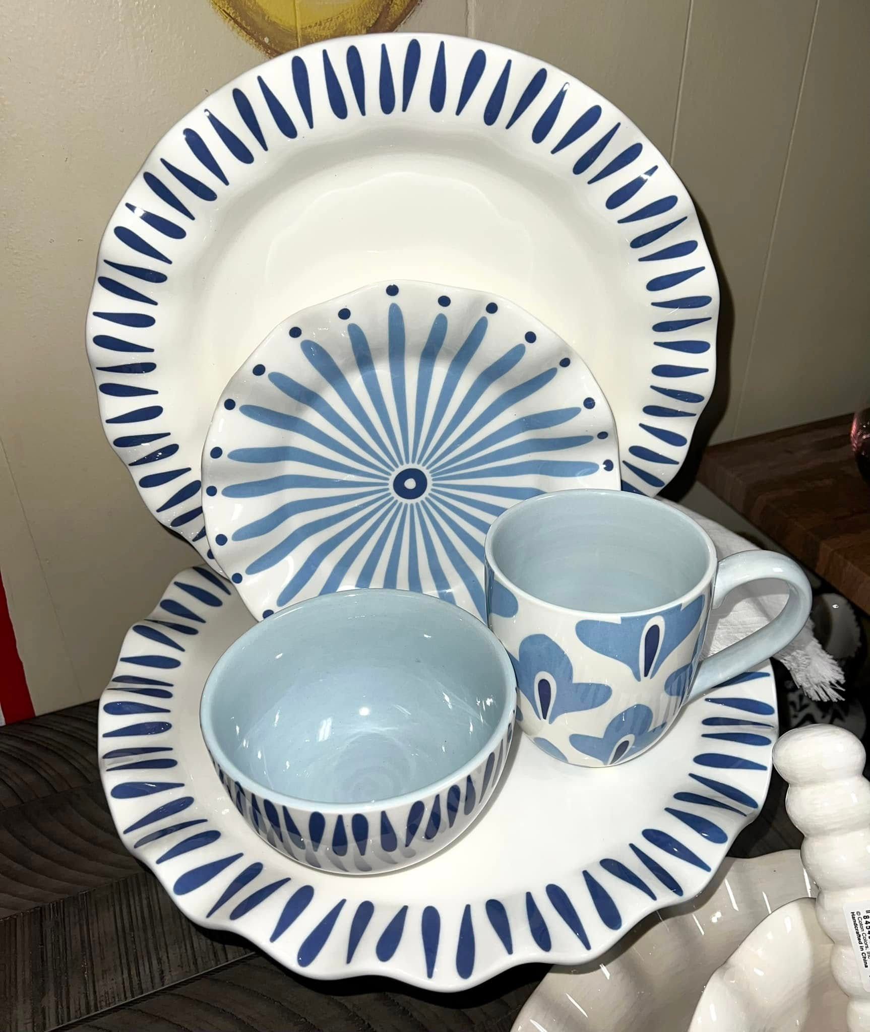 Assortment of blue and white patterned tableware: plates, bowls, and a mug.