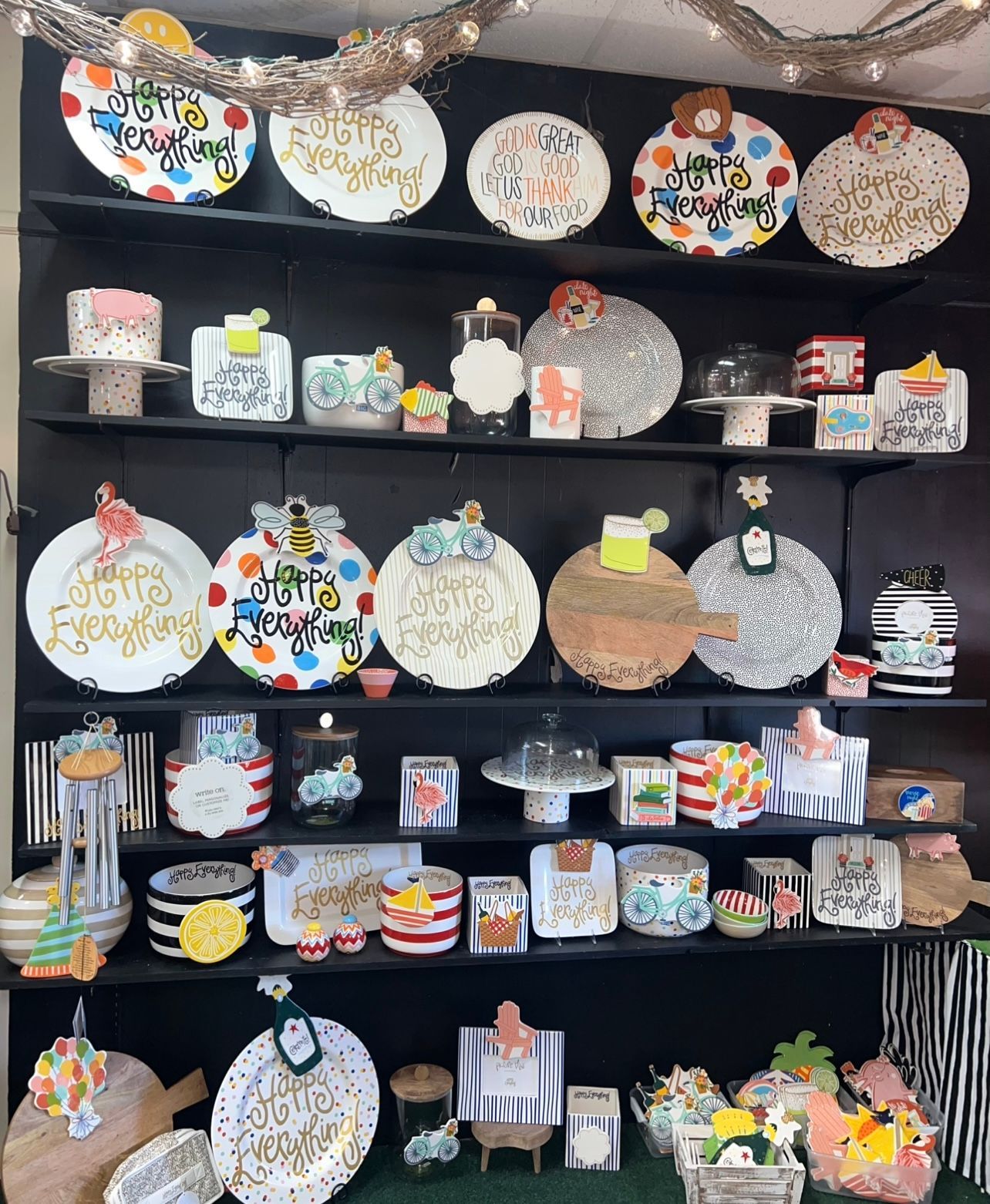 Shelves displaying colorful ceramics, including plates, serving trays, and cake stands, with whimsical designs.