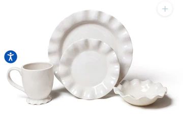 White ceramic dishes and a mug with ruffled edges.
