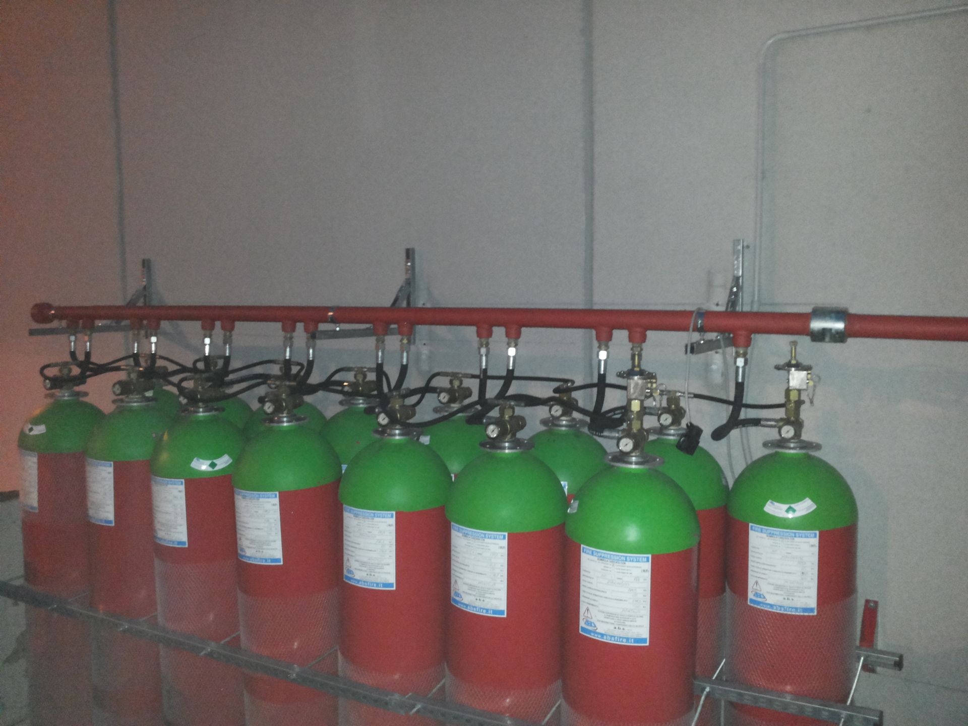 Un mucchio di cilindri rossi e verdi sono allineati su uno scaffale