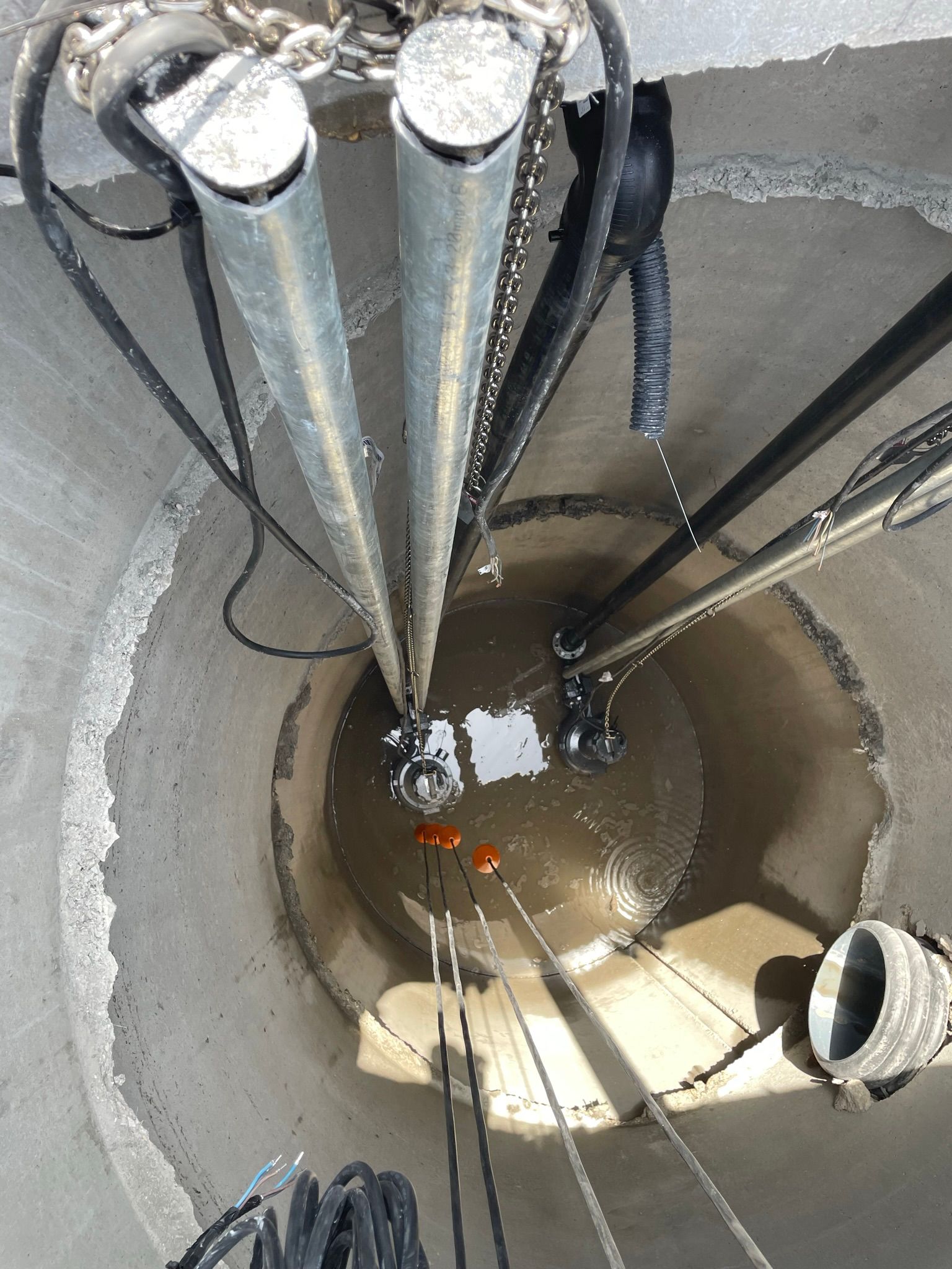 Un uomo è in piedi in un buco da cui escono un mucchio di tubi.