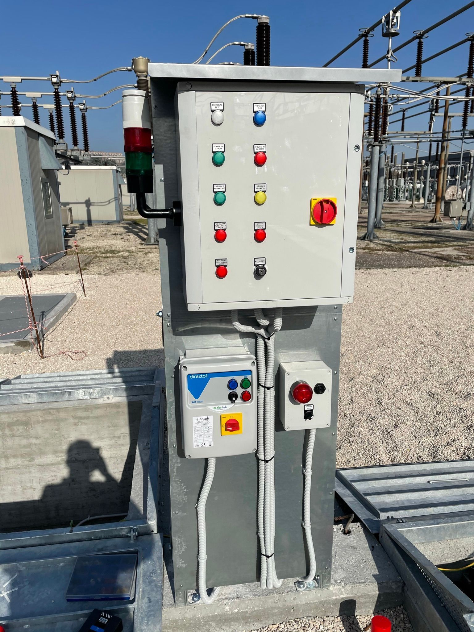 Una grande scatola elettrica è posta in cima a un campo di ghiaia.