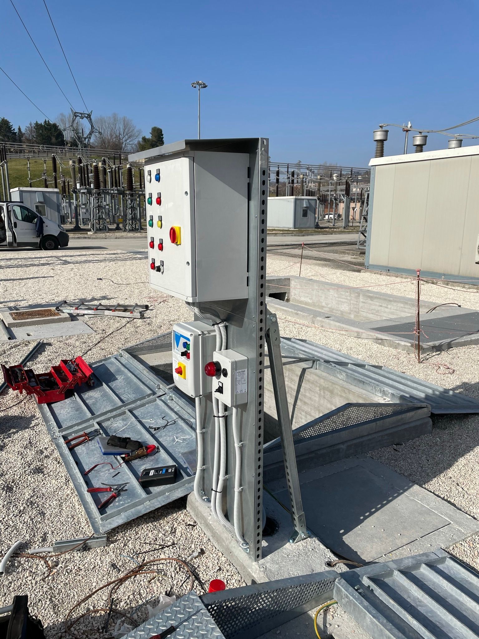 Una grande scatola elettrica è posta in cima a un mucchio di ghiaia.