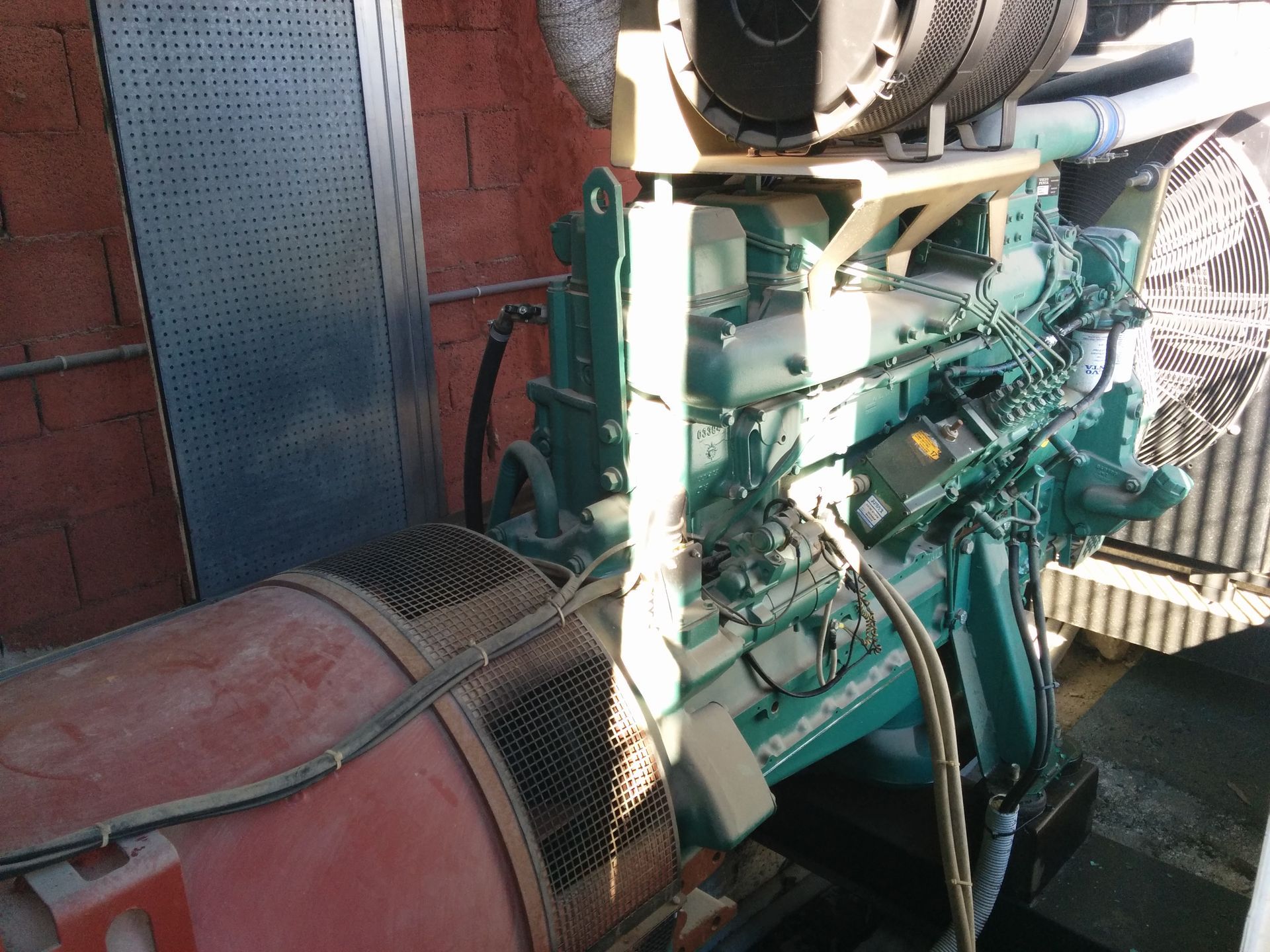 Un motore verde e bianco è parcheggiato davanti a un muro di mattoni