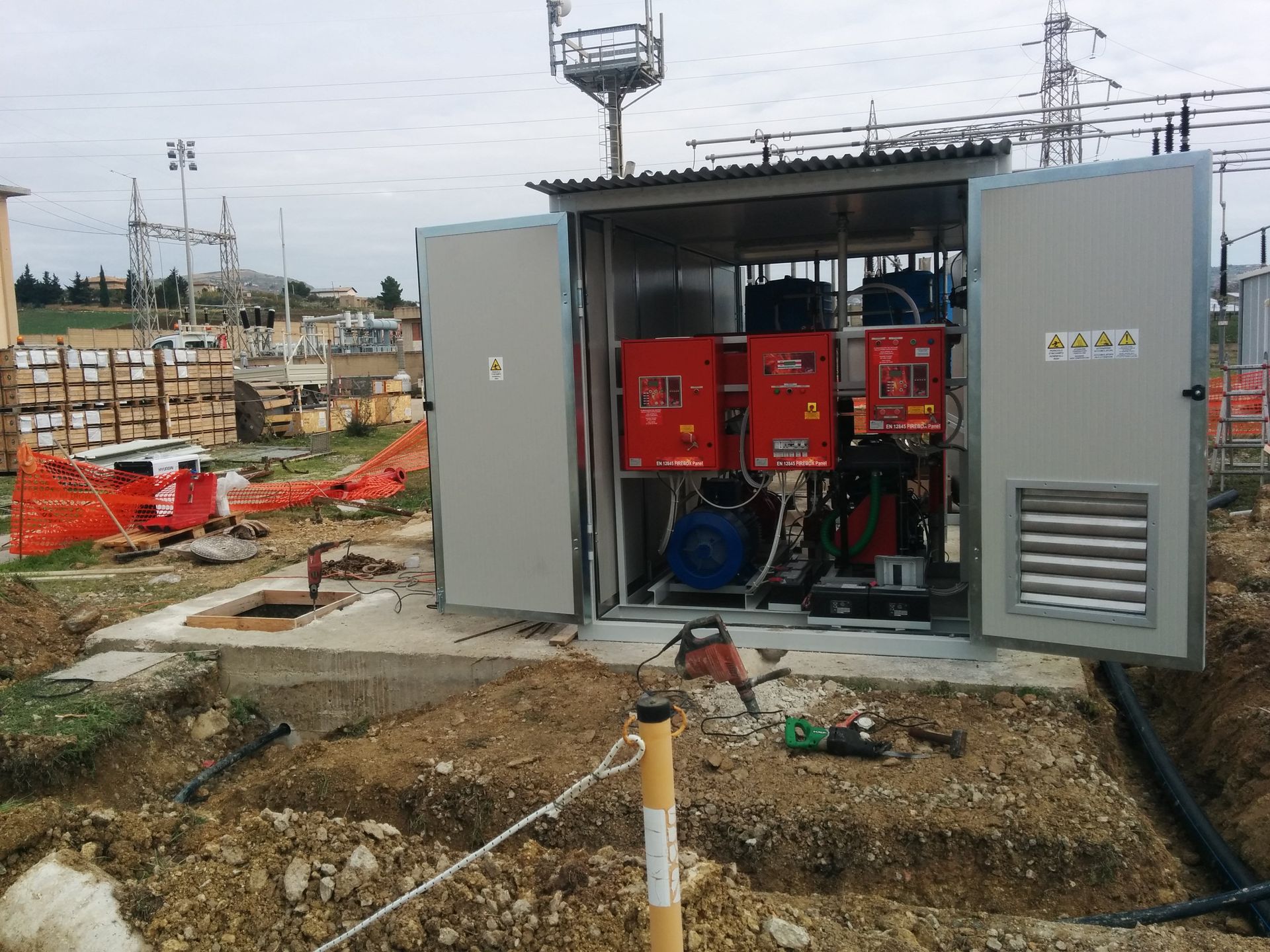 Una grande scatola elettrica si trova in mezzo a un campo sterrato.