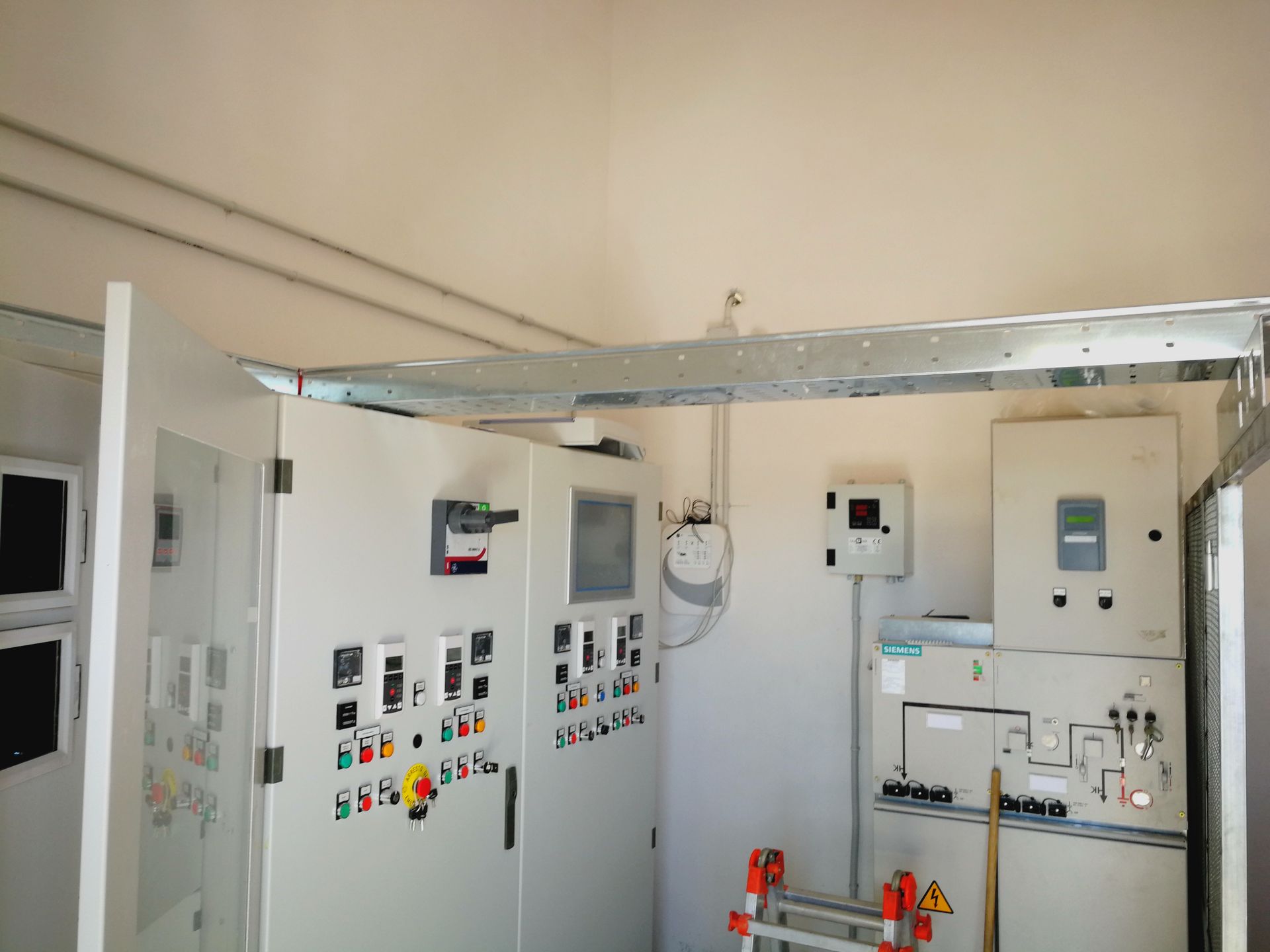 Una stanza con un sacco di apparecchiature elettriche e una scala al suo interno.