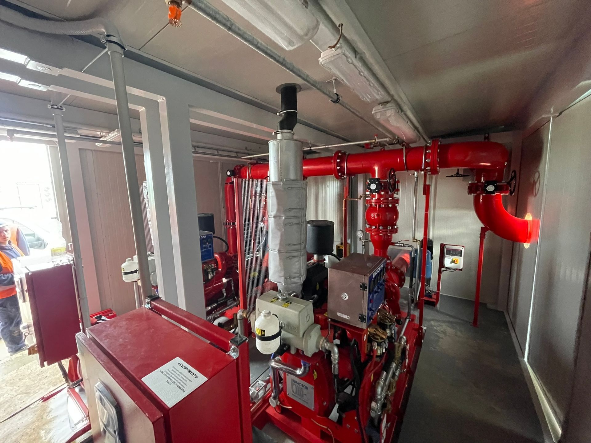 Una stanza piena di tubi e scatole rosse.