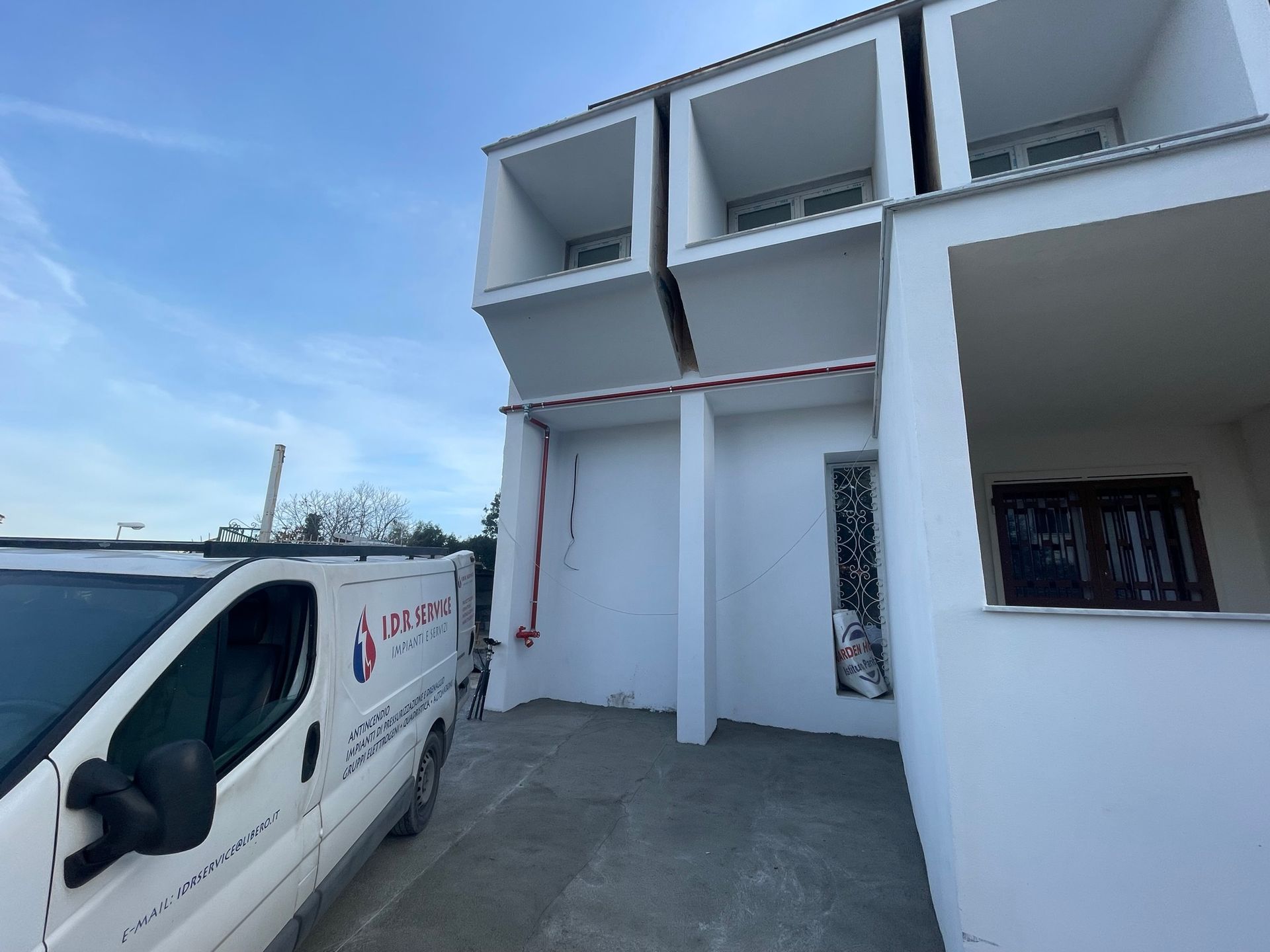 Un furgone bianco è parcheggiato davanti a un edificio bianco