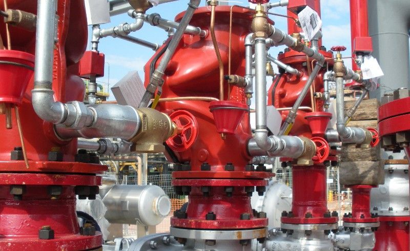 Un gruppo di tubi e valvole rossi sono allineati in fila.