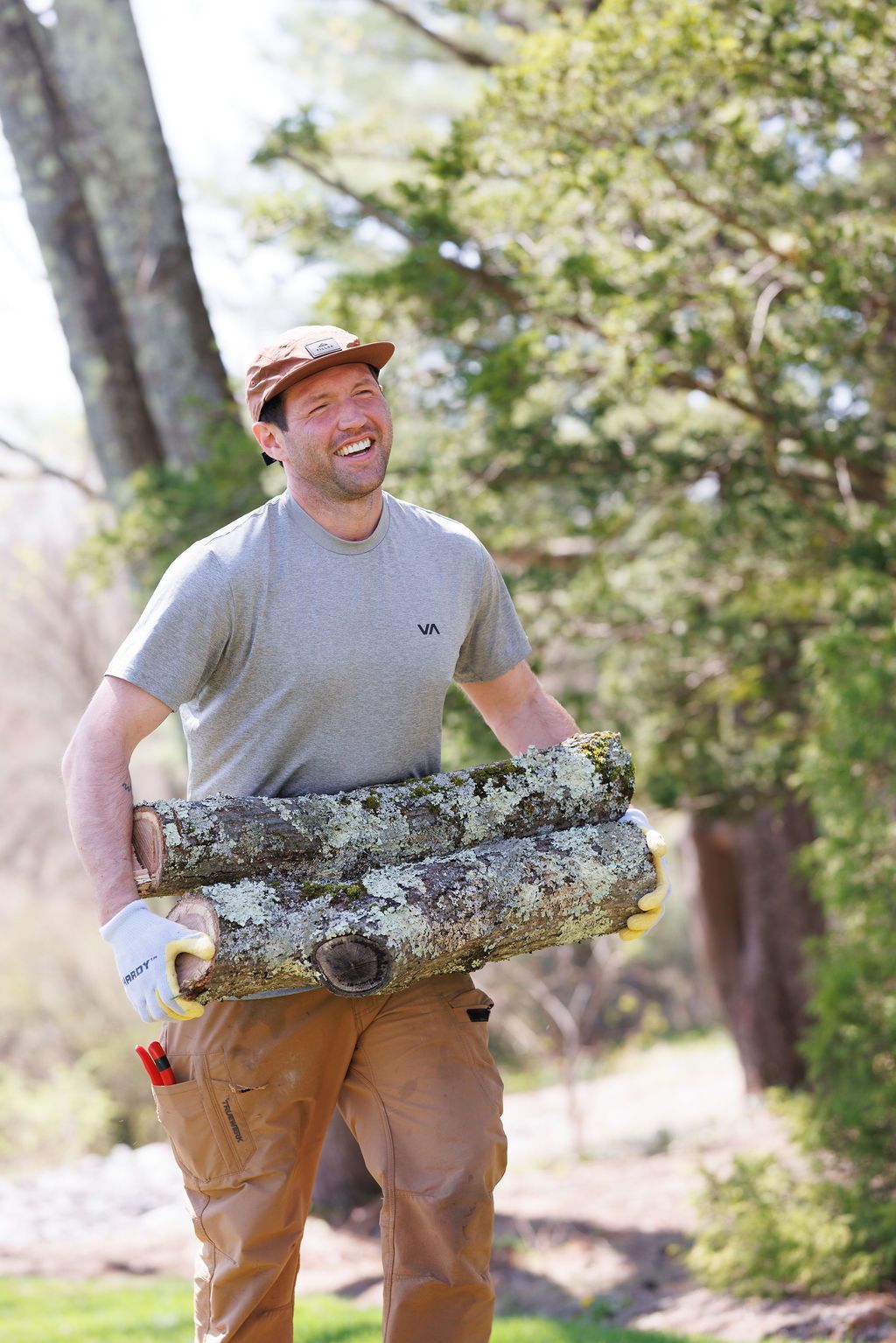 A man is carrying a large log in his hands.