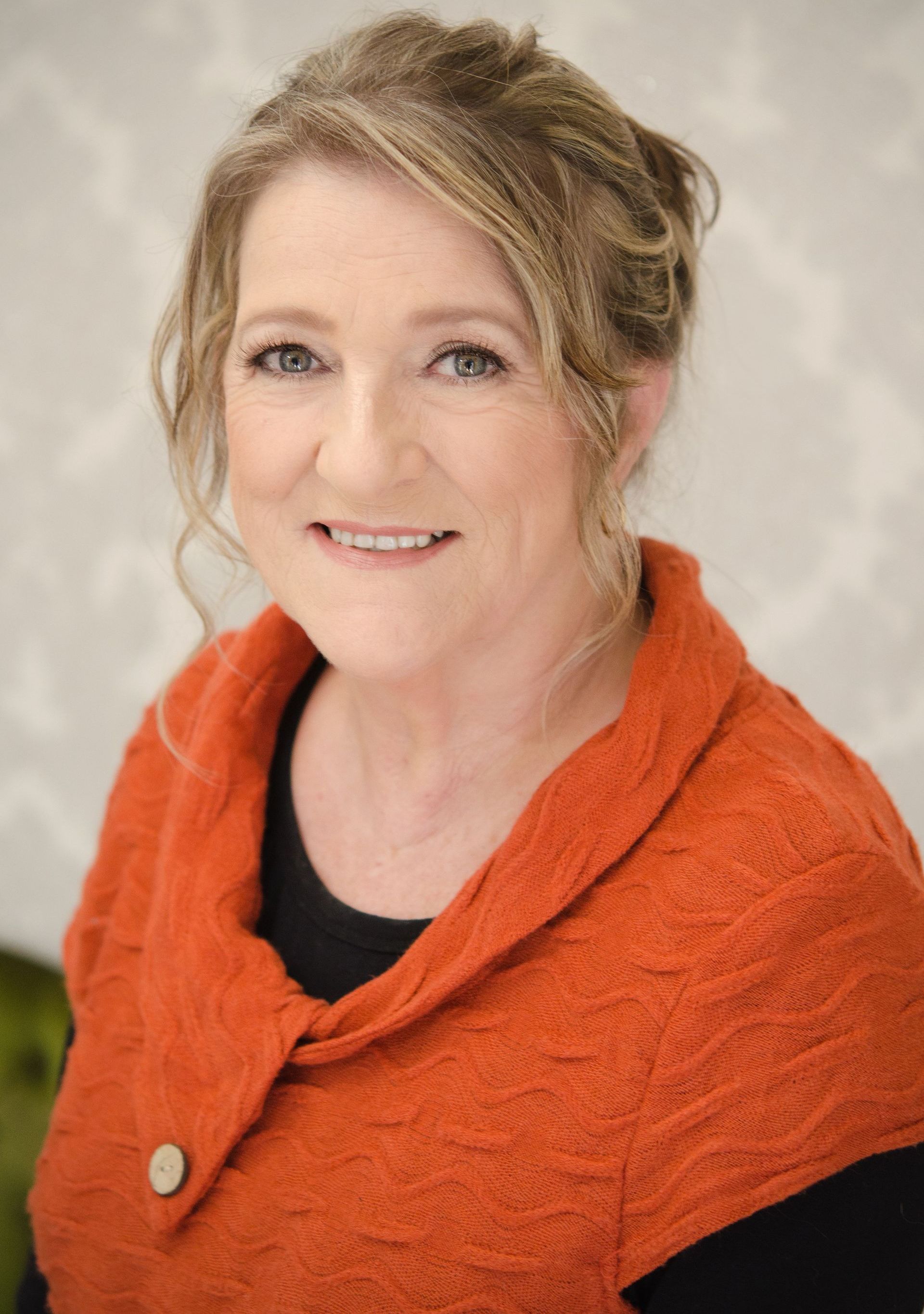 A Woman Is Sitting At A Desk Talking On A Phone — NR Bookkeeping In Alstonville, NSW