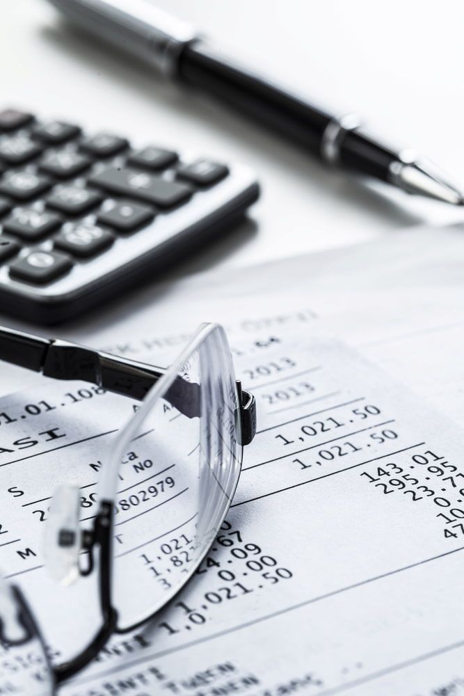 Eyeglasses Resting on a Receipt With a Calculator and Pen — NR Bookkeeping in Lismore, NSW