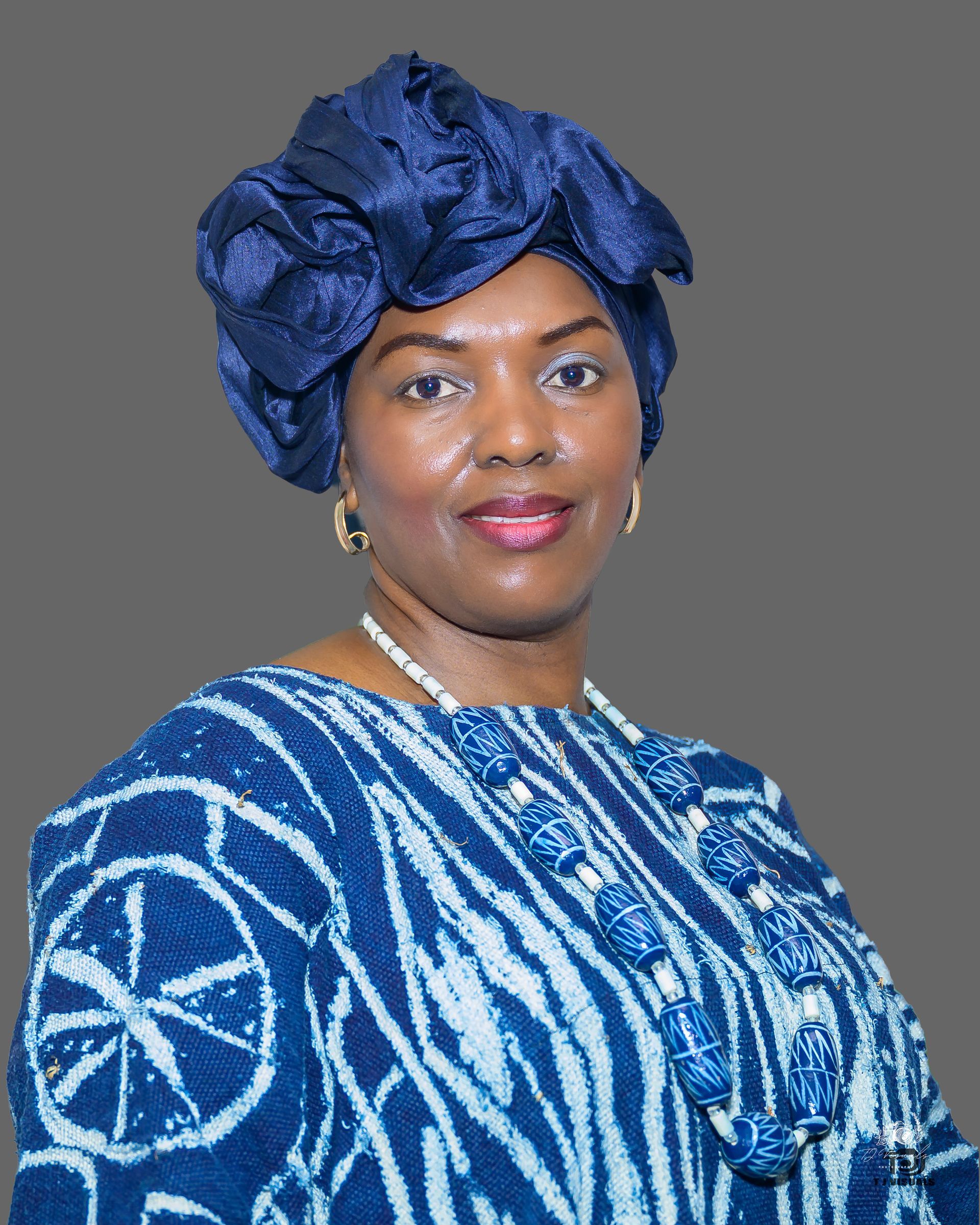 Man with glasses and beard wearing a red polo shirt, smiling slightly.