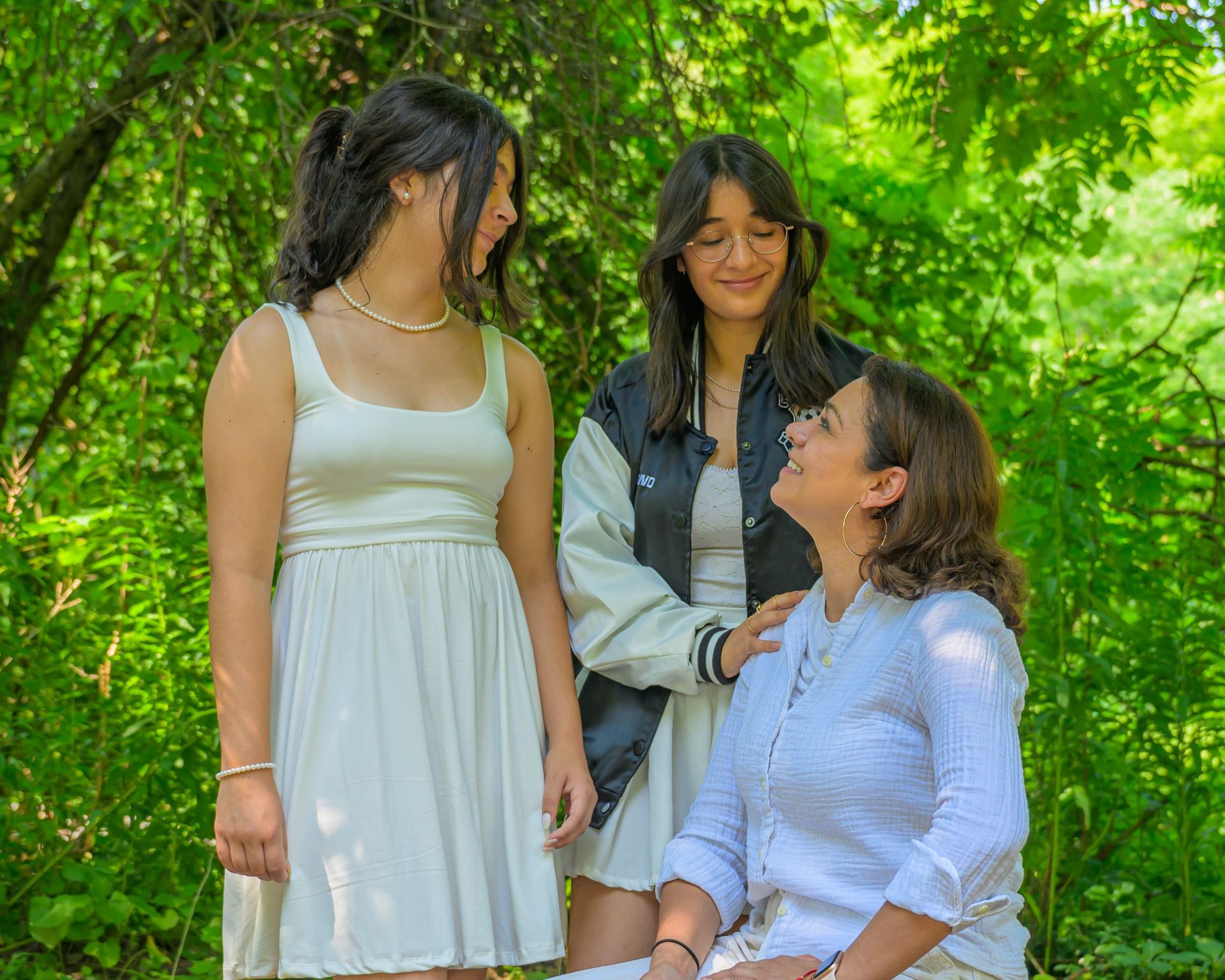 A family poses for a photo indoors; photographer in the foreground, two young girls hold a balloon.