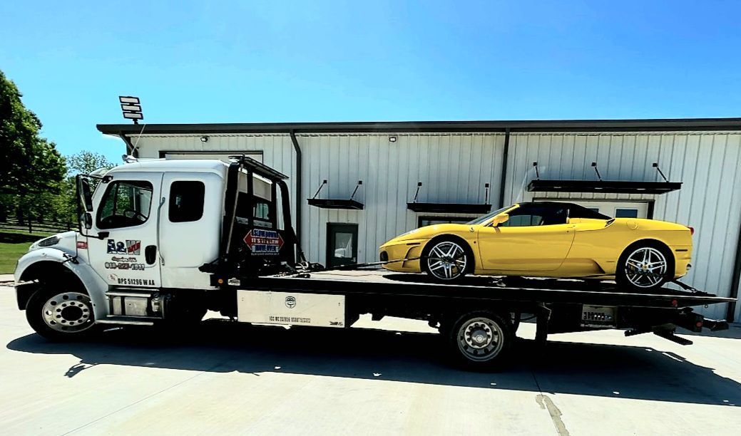 A yellow car is being towed by a tow truck.