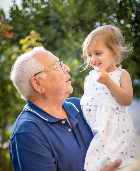 A man is holding a little girl in his arms.