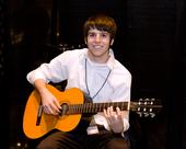 Boy in white polo and classical guitar