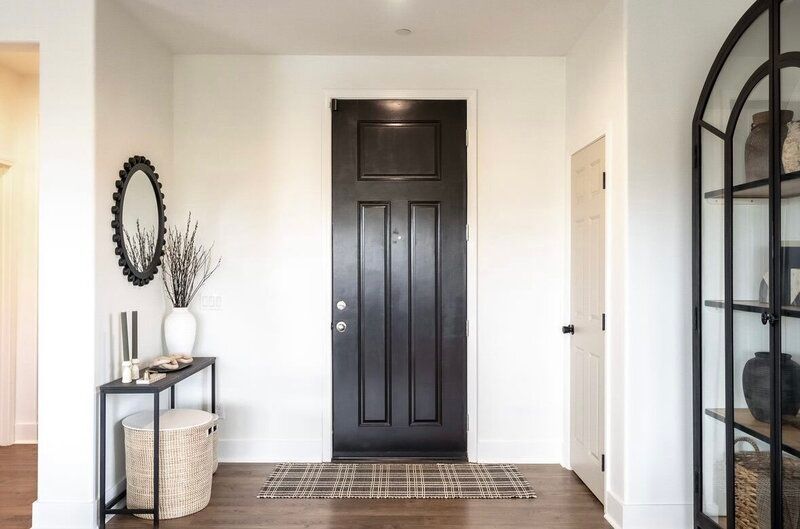 There is a black door in the middle of the hallway.