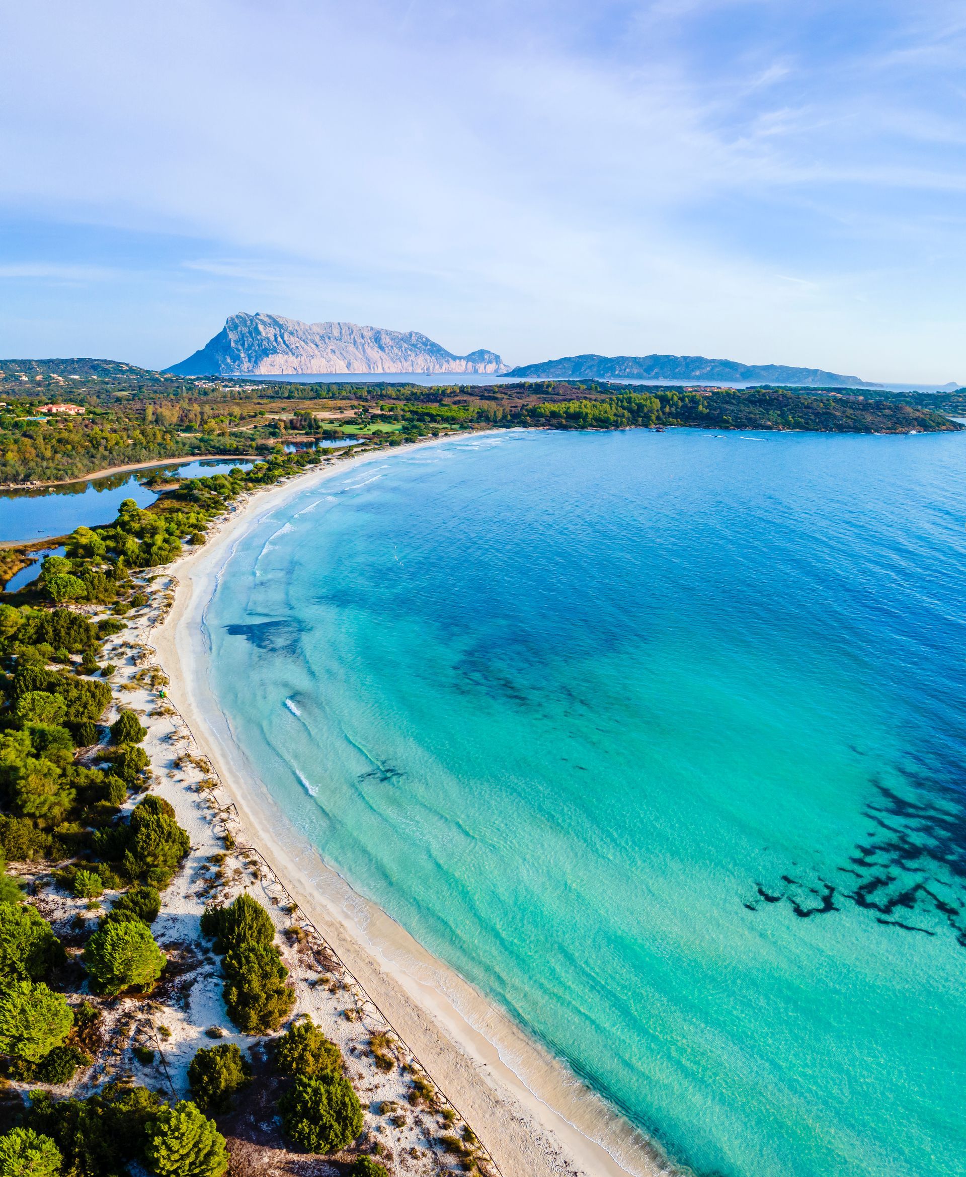 Una vista aerea di una spiaggia con una montagna sullo sfondo.