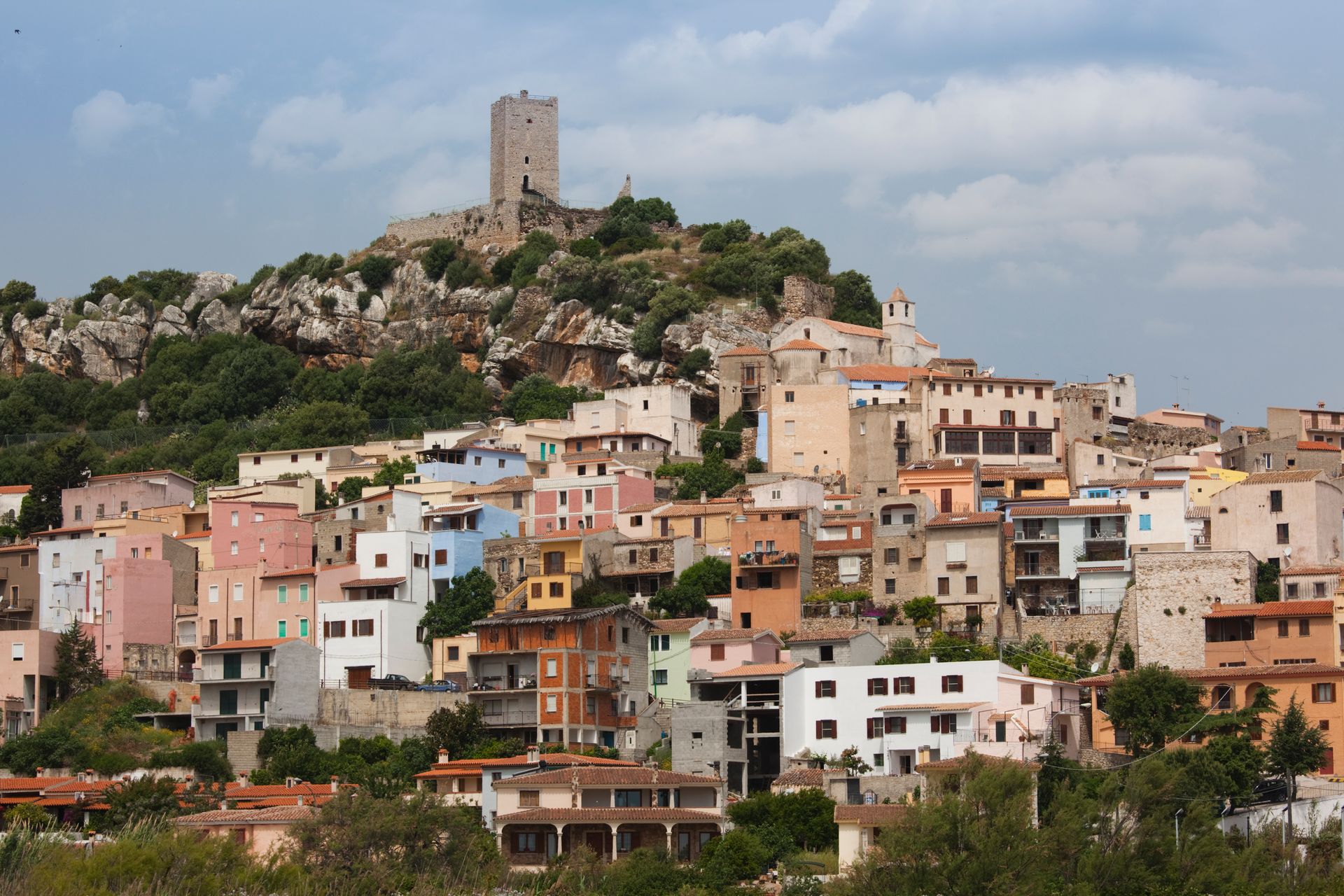 Una piccola città in cima a una collina con un castello sullo sfondo