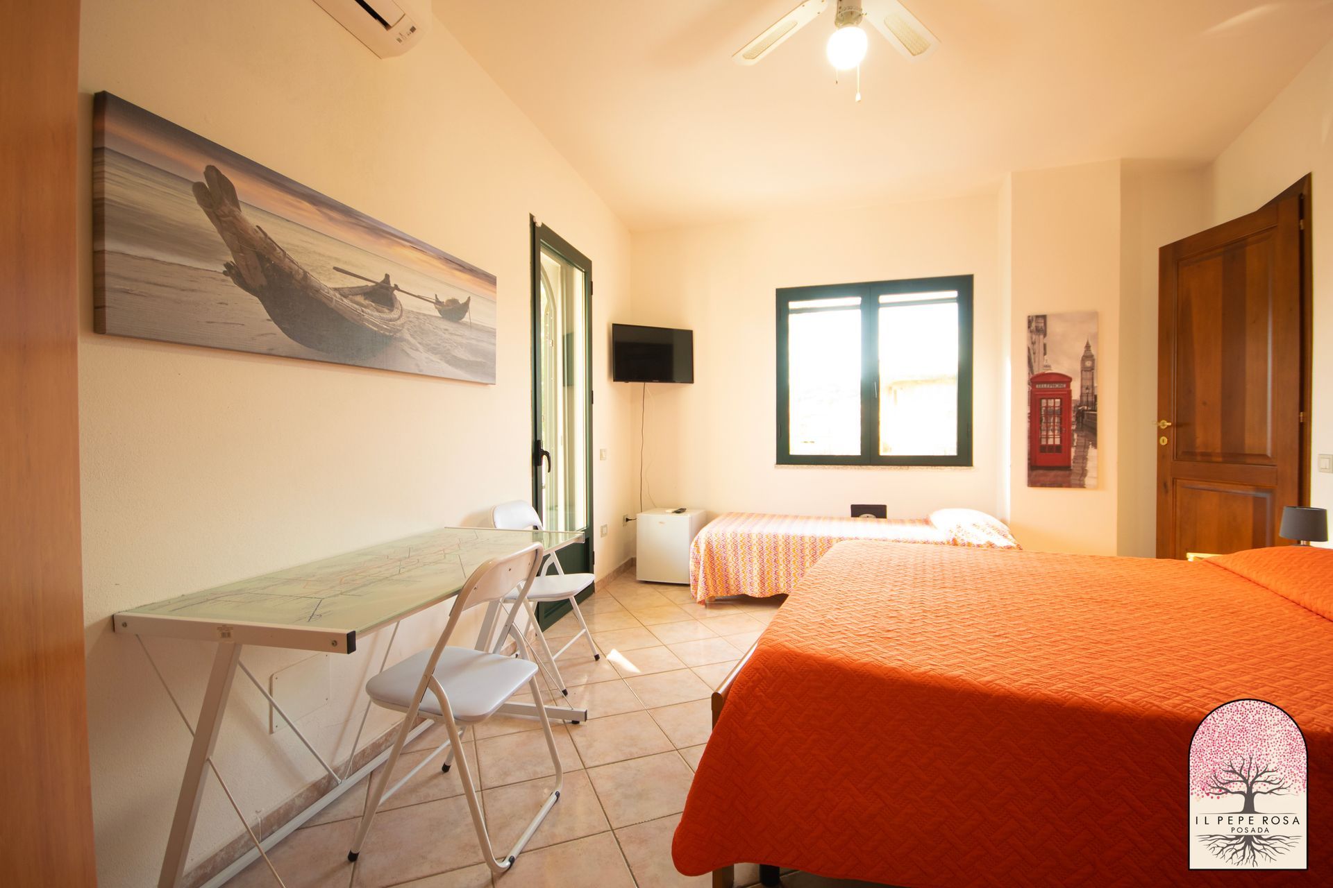 Una camera da letto con un letto, una scrivania, delle sedie e un quadro sul muro.