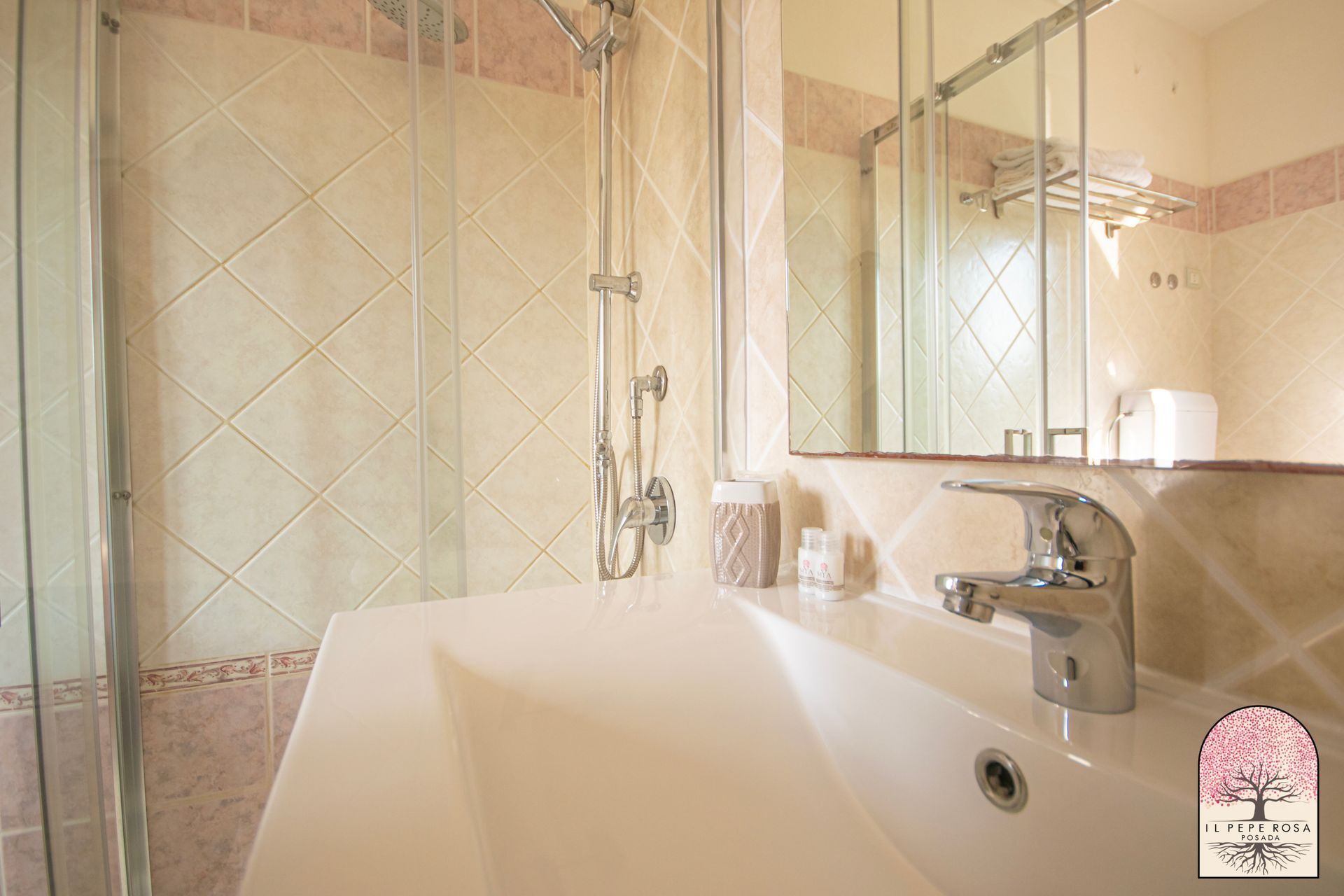 Un bagno con lavandino, doccia e specchio.