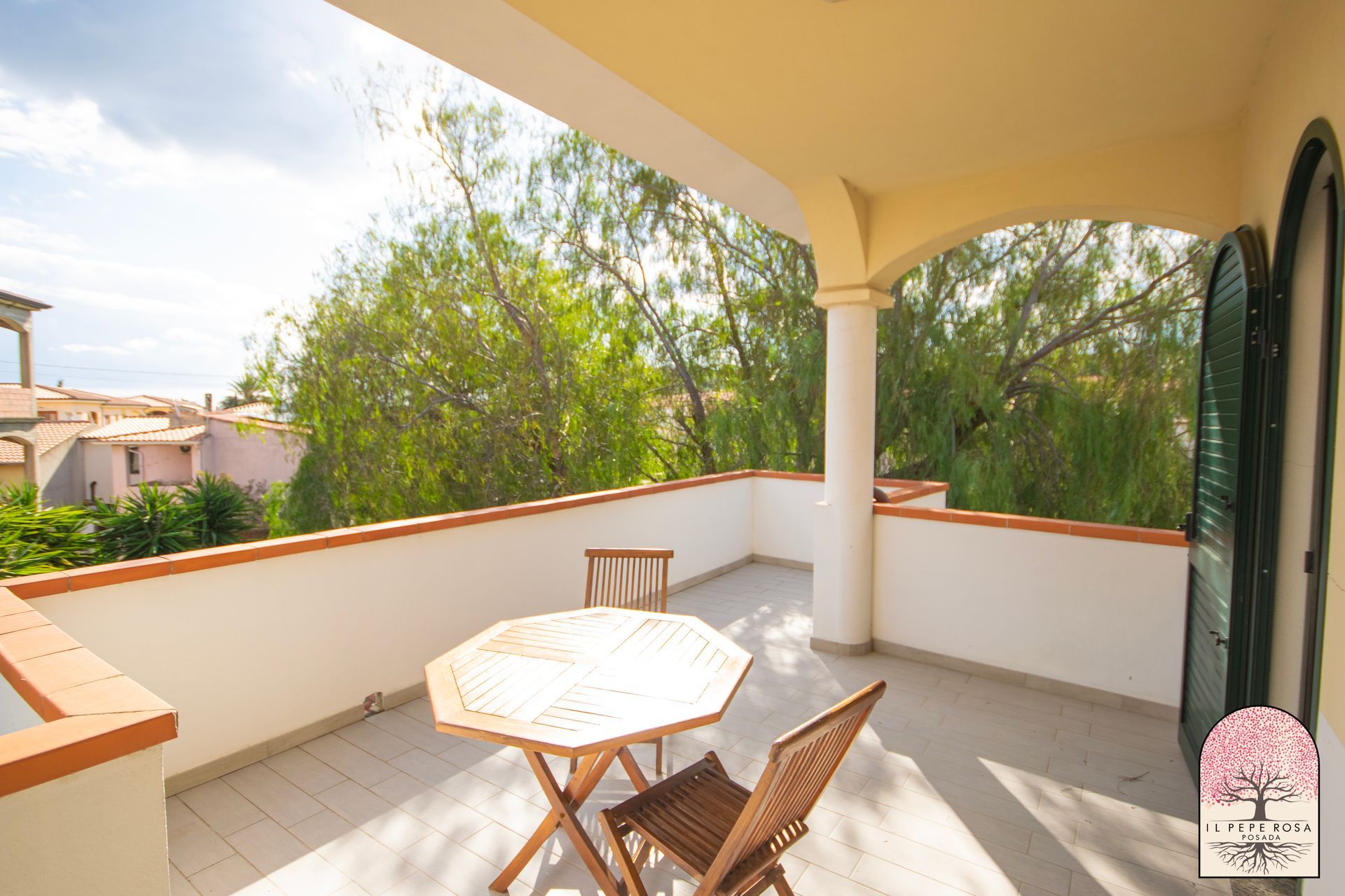 C'è un tavolo e delle sedie sul balcone.