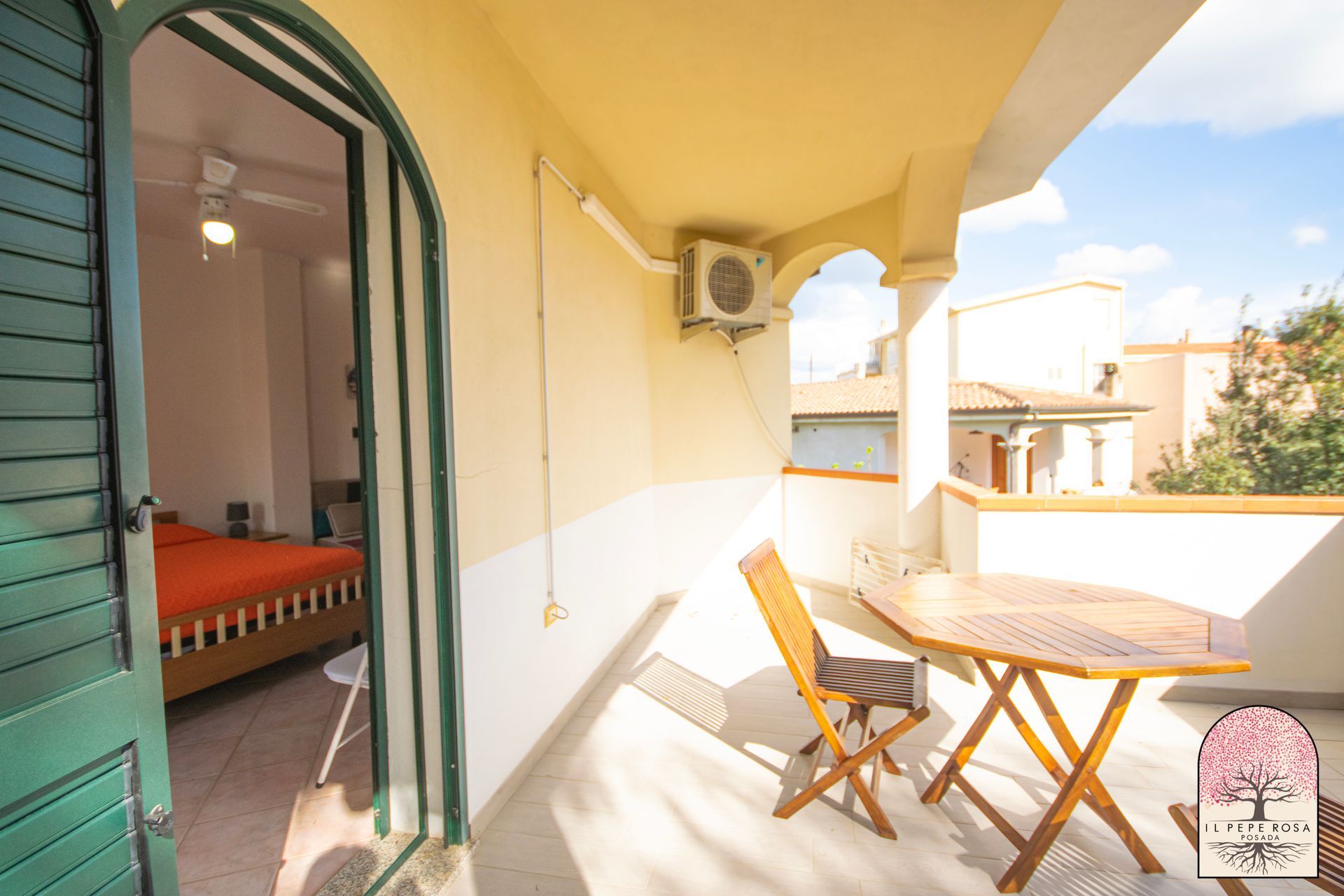 Un balcone con tavolo e sedie di fronte alla camera da letto