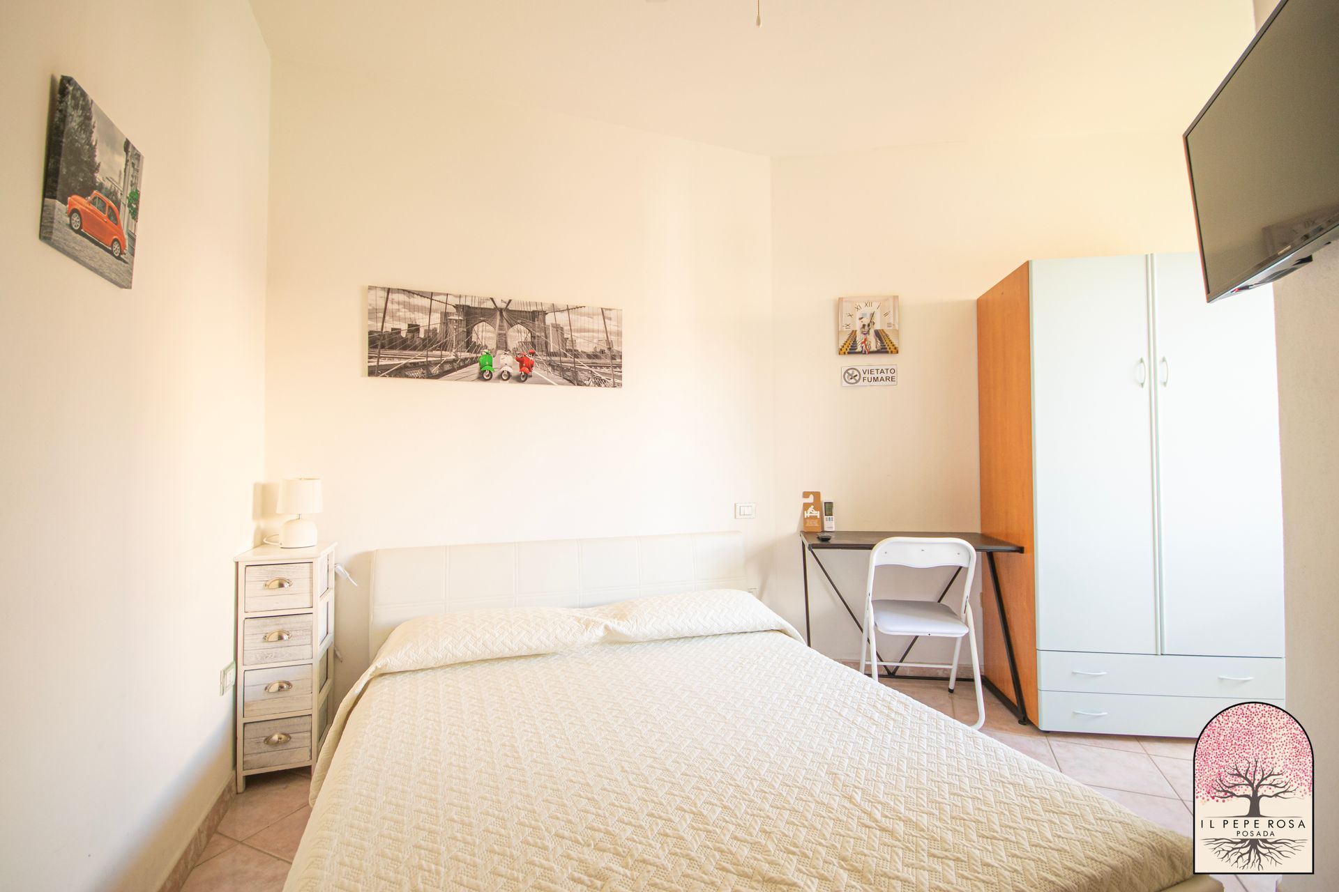 Una camera da letto con un letto, una scrivania e una televisione