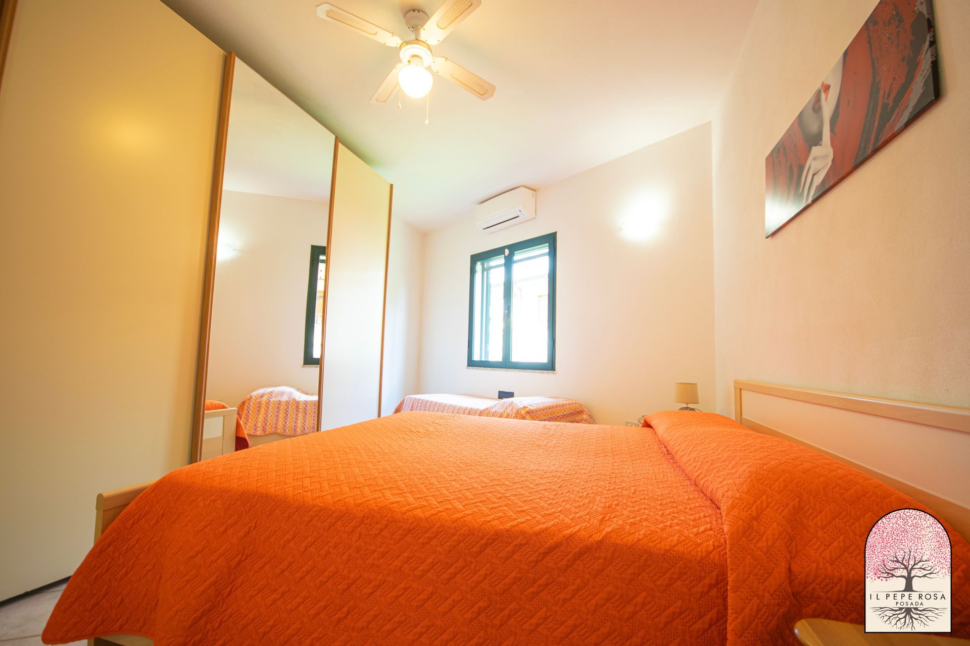 Una camera da letto con due letti e un ventilatore a soffitto